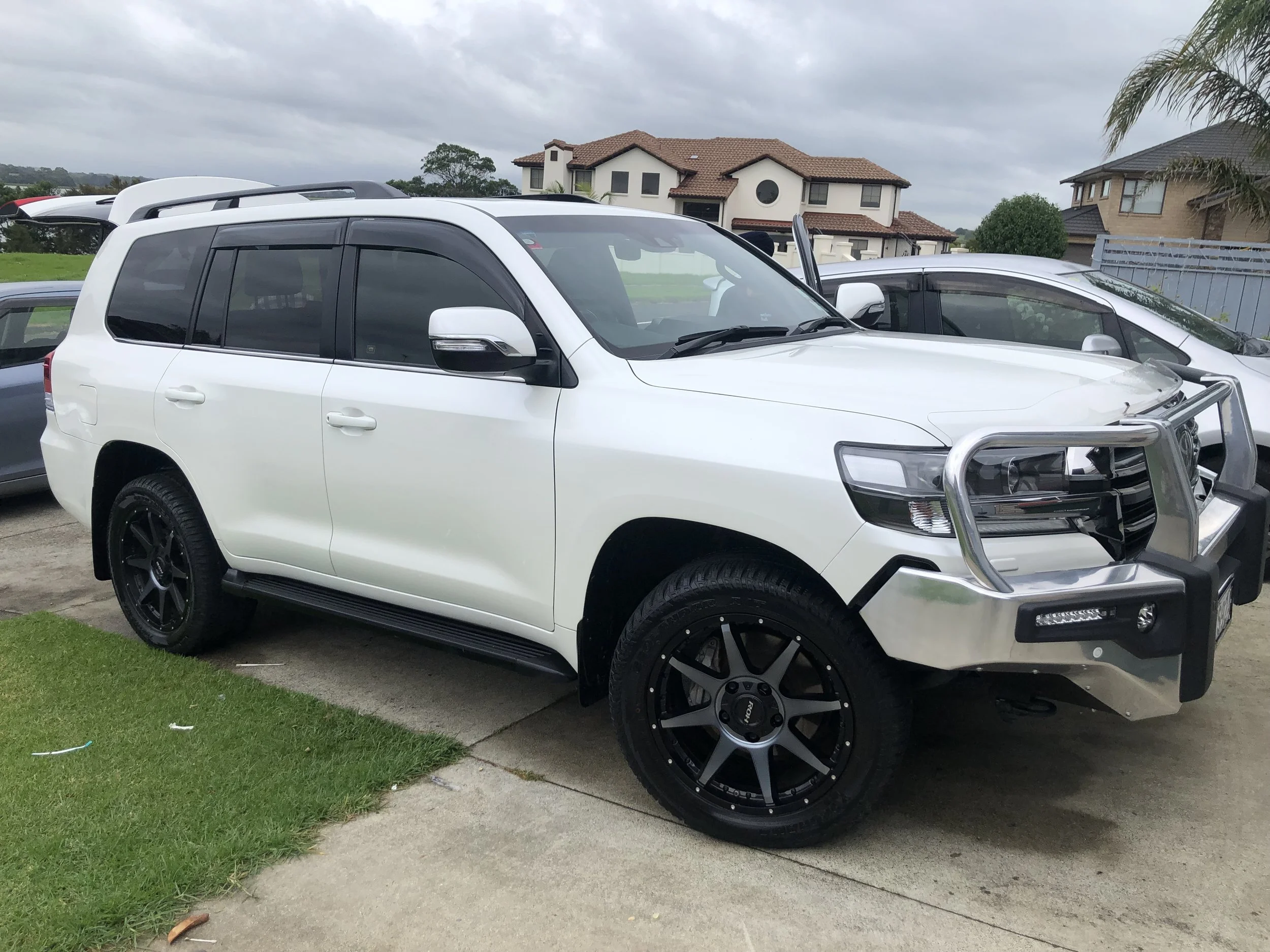 Mobile car valet service restoring white SUV exterior to showroom shine at home.