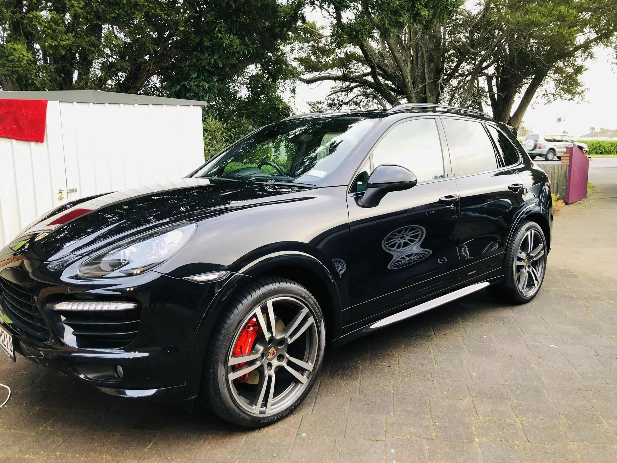 Shiny black sedan after professional car detailing and wax finish by Dirt Devils Auto Valet.