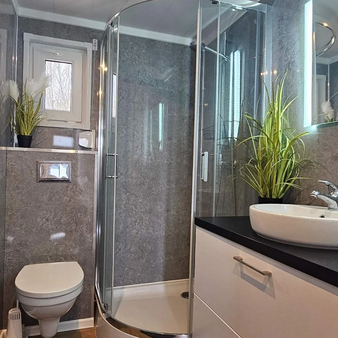 Modernes Badezimmer im Mobilheim Marine Glück mit Dusche, WC und Aufsatzwaschbecken