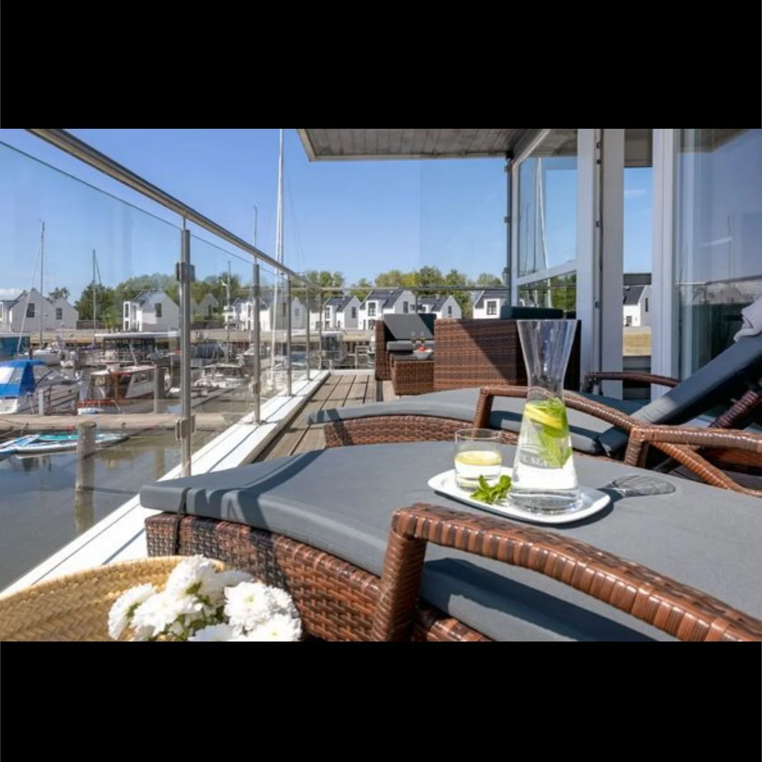Balkon des Floating House Yachthafen Perle mit Sonnenliegen und Blick auf den Hafen