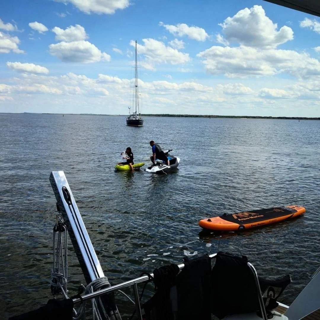 Gäste starten mit SUP Board und Jetski vom Katamaran aus auf der Ostsee bei Usedom