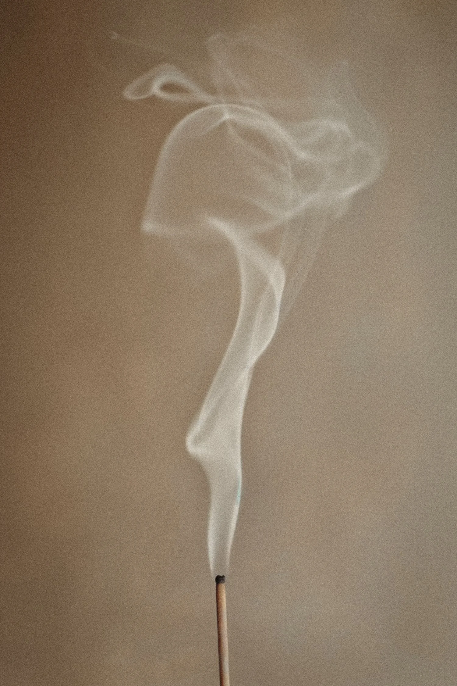 Smoke rising from incense used for energy cleansing and intuitive healing practices.