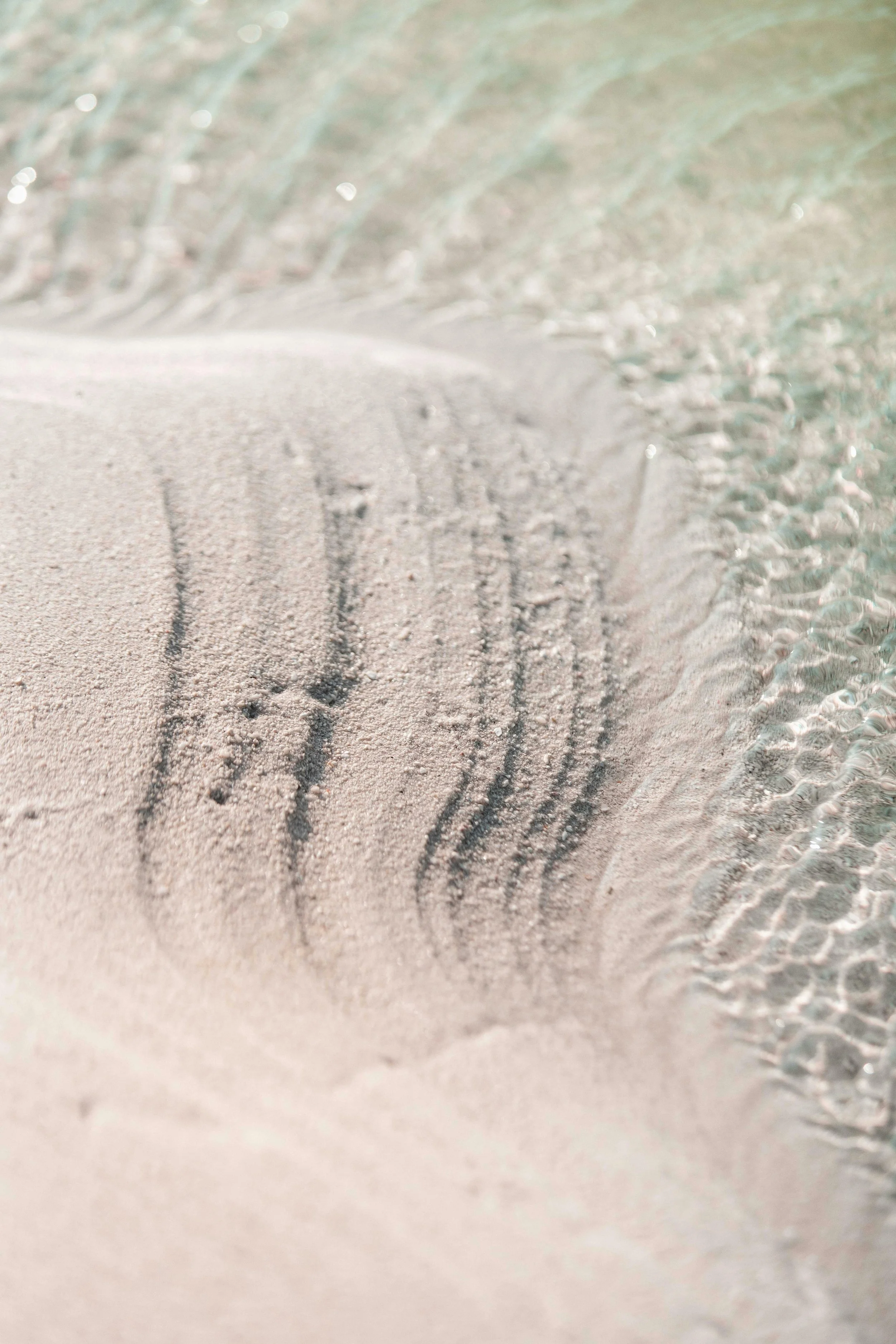 Cascading lines in a sand at the water's edge