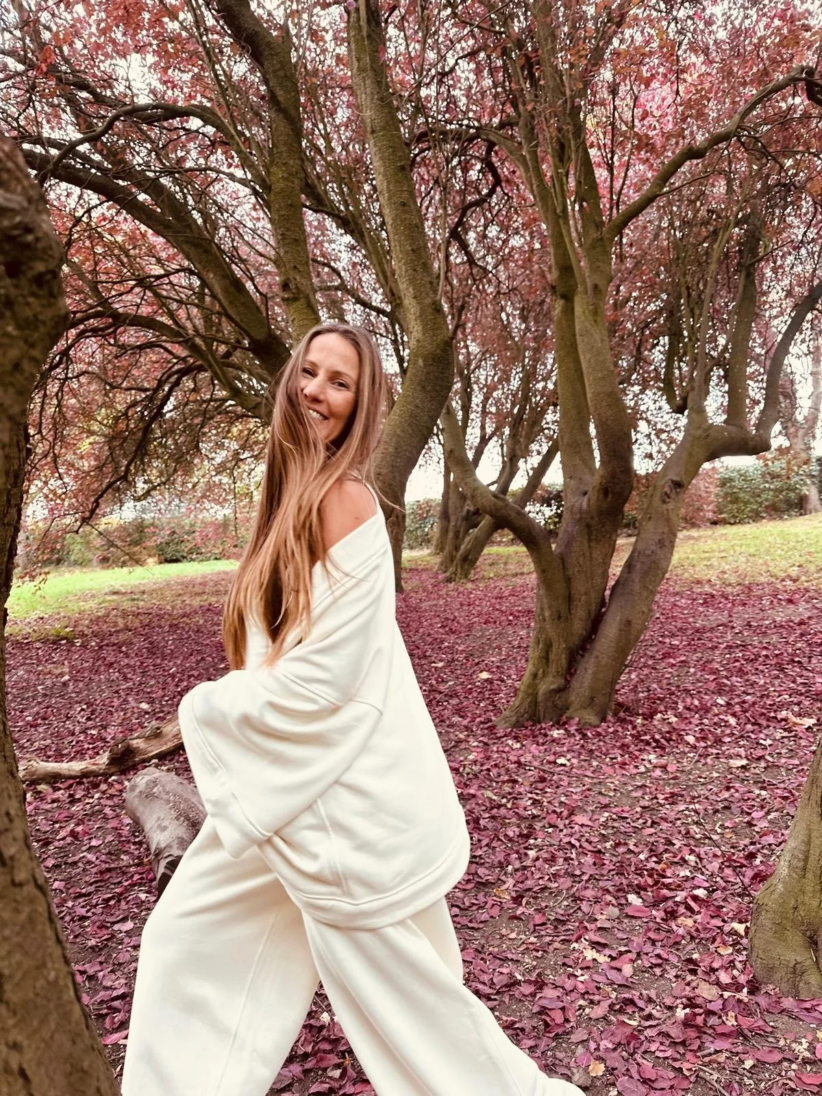 A picture of brand founder Sarah Baily in a custom design lounge suit against autumn leaves