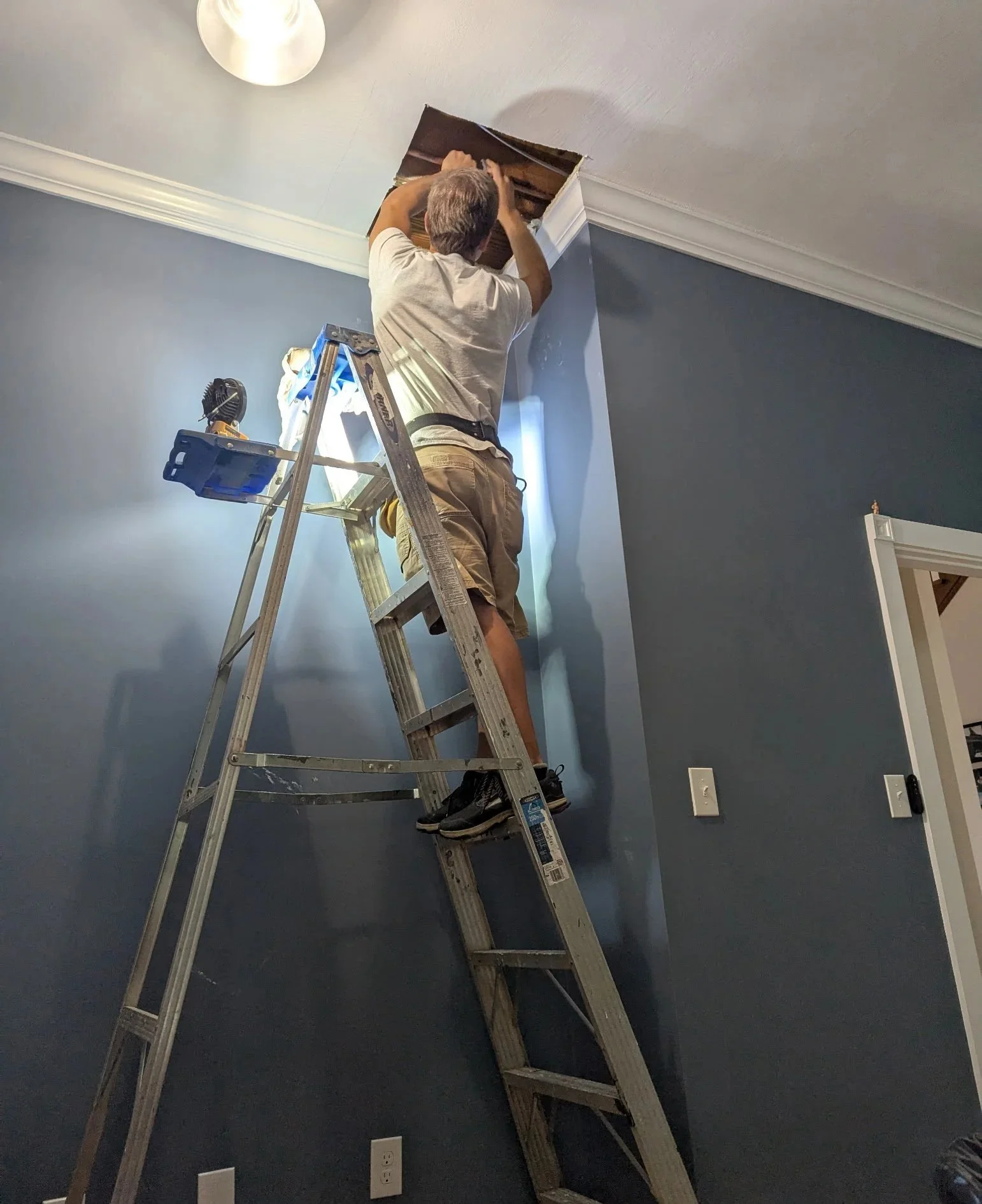 Handyman fixing a pipe leak in the ceiling