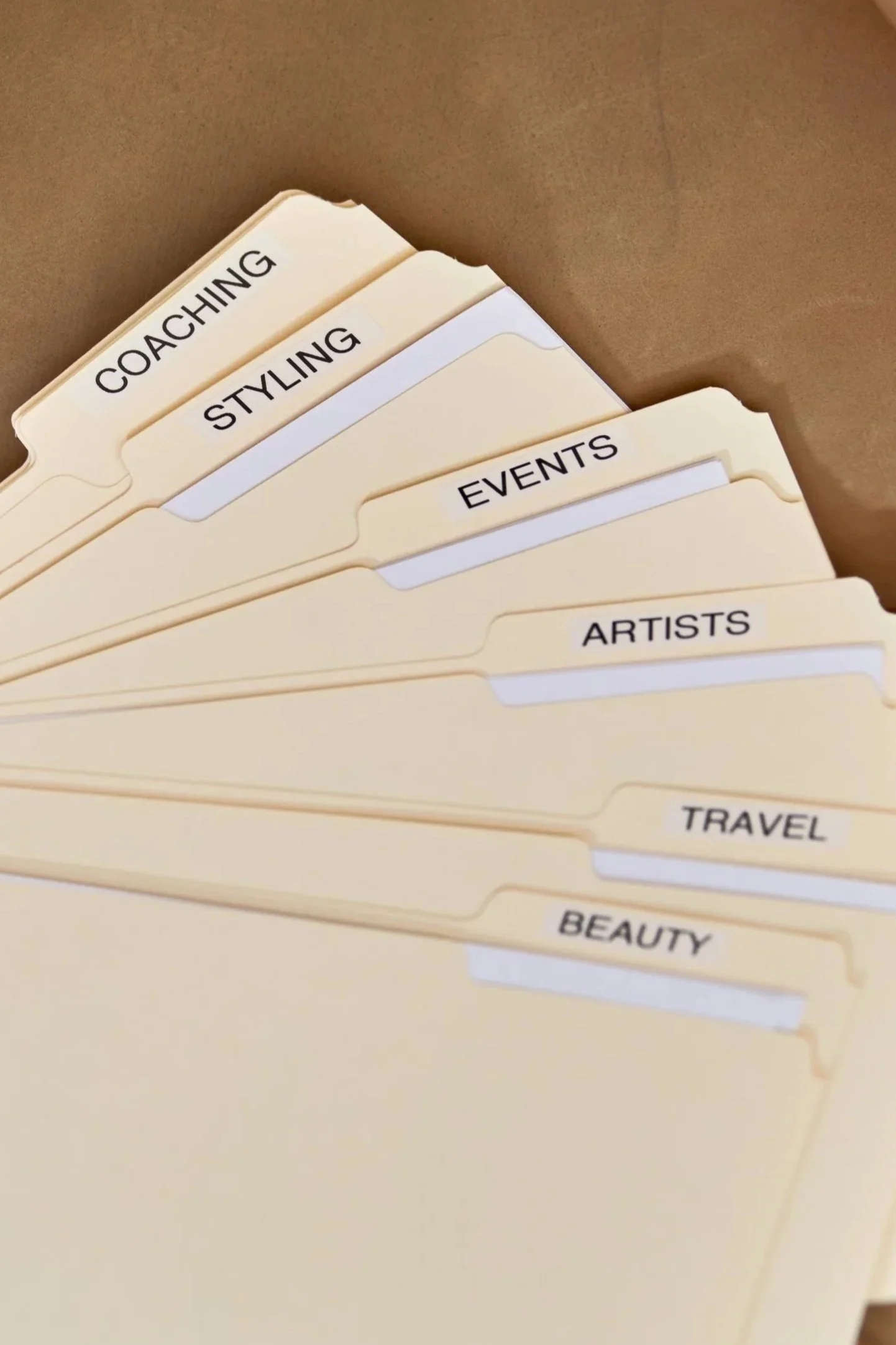 Labeled file folders for coaching, styling, events, artists, travel, coaching, and beauty, representing lawyer drafted contract templates for a range of creative and service based businesses.