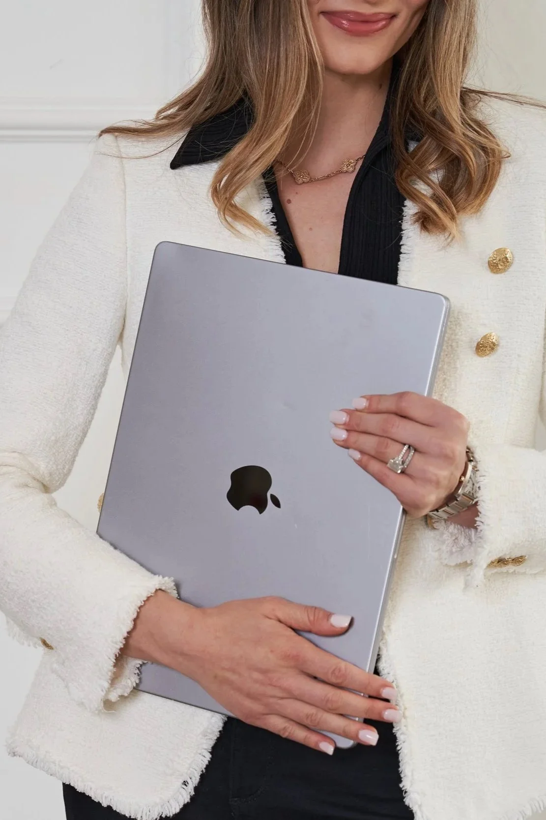 Woman holding a laptop, representing the creation of lawyer drafted contract templates for creative professionals and small business owners.