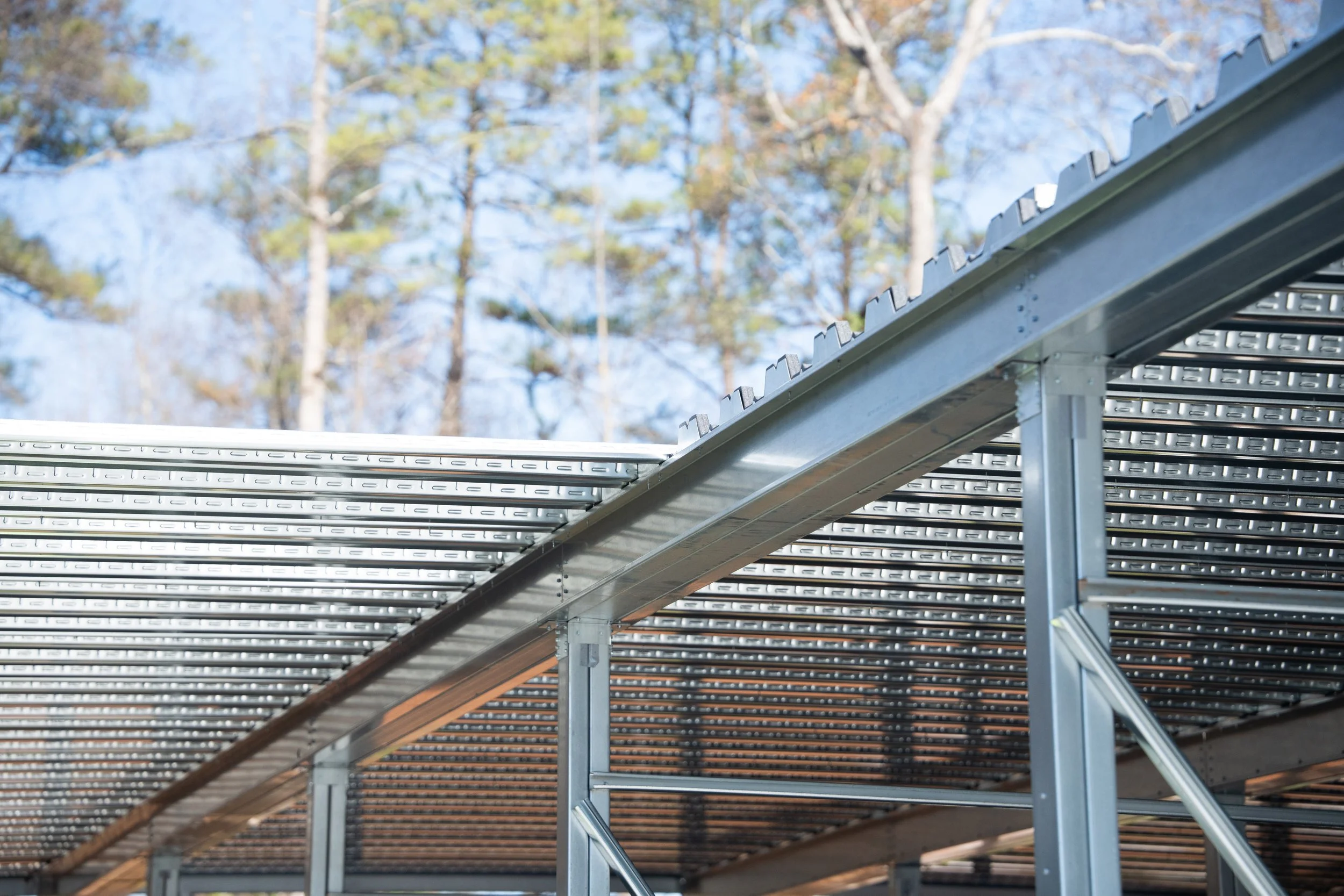Metal joists with a sheet metal roof behind them