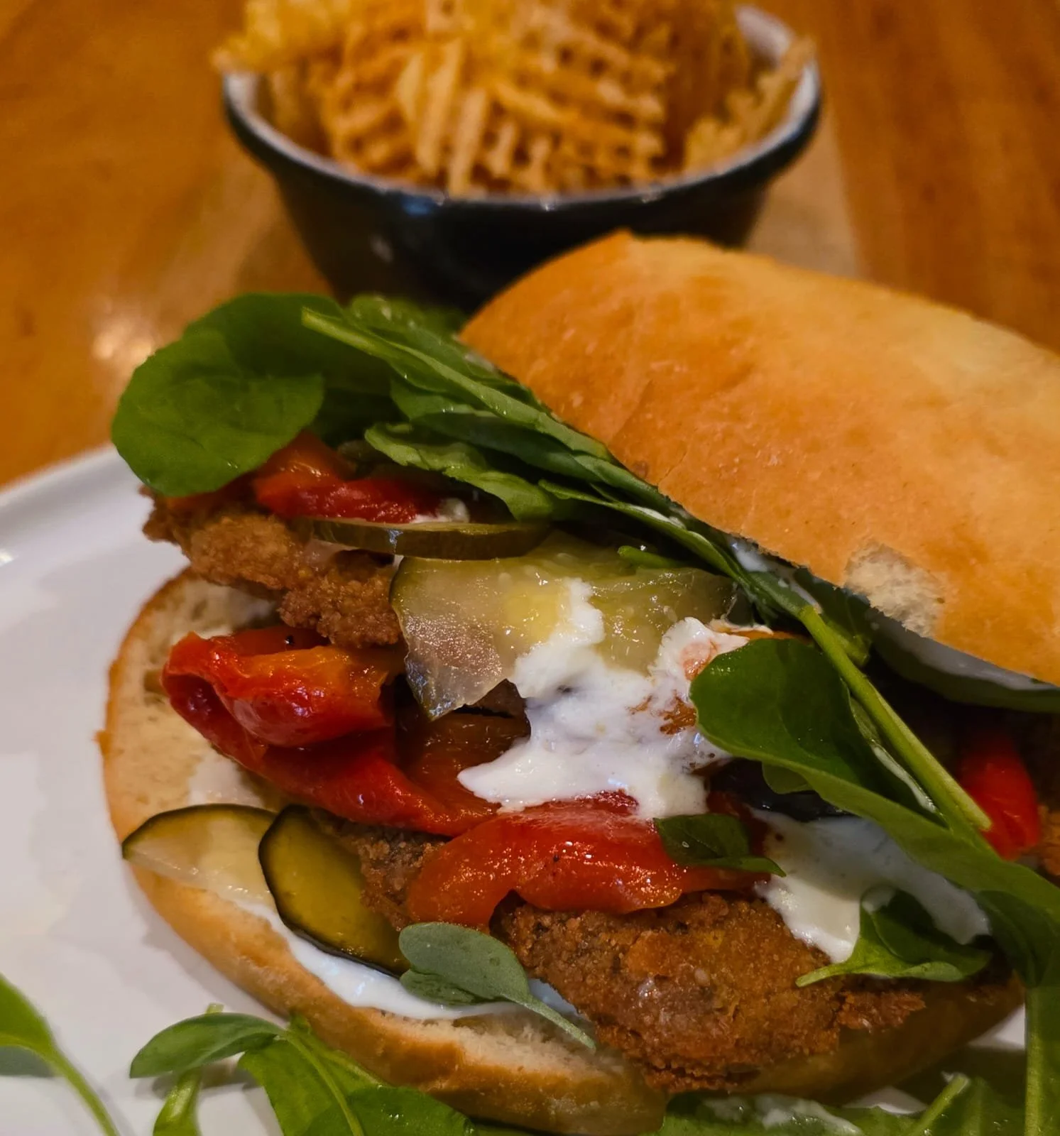 Sándwich de vegetales en pan artesanal, acompañado de papas fritas