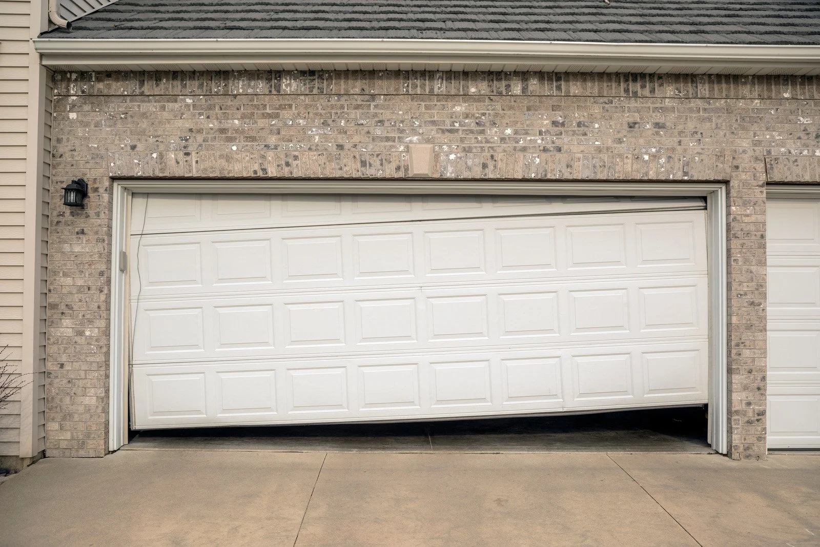 residential garage door snapped spring hanging from ceiling