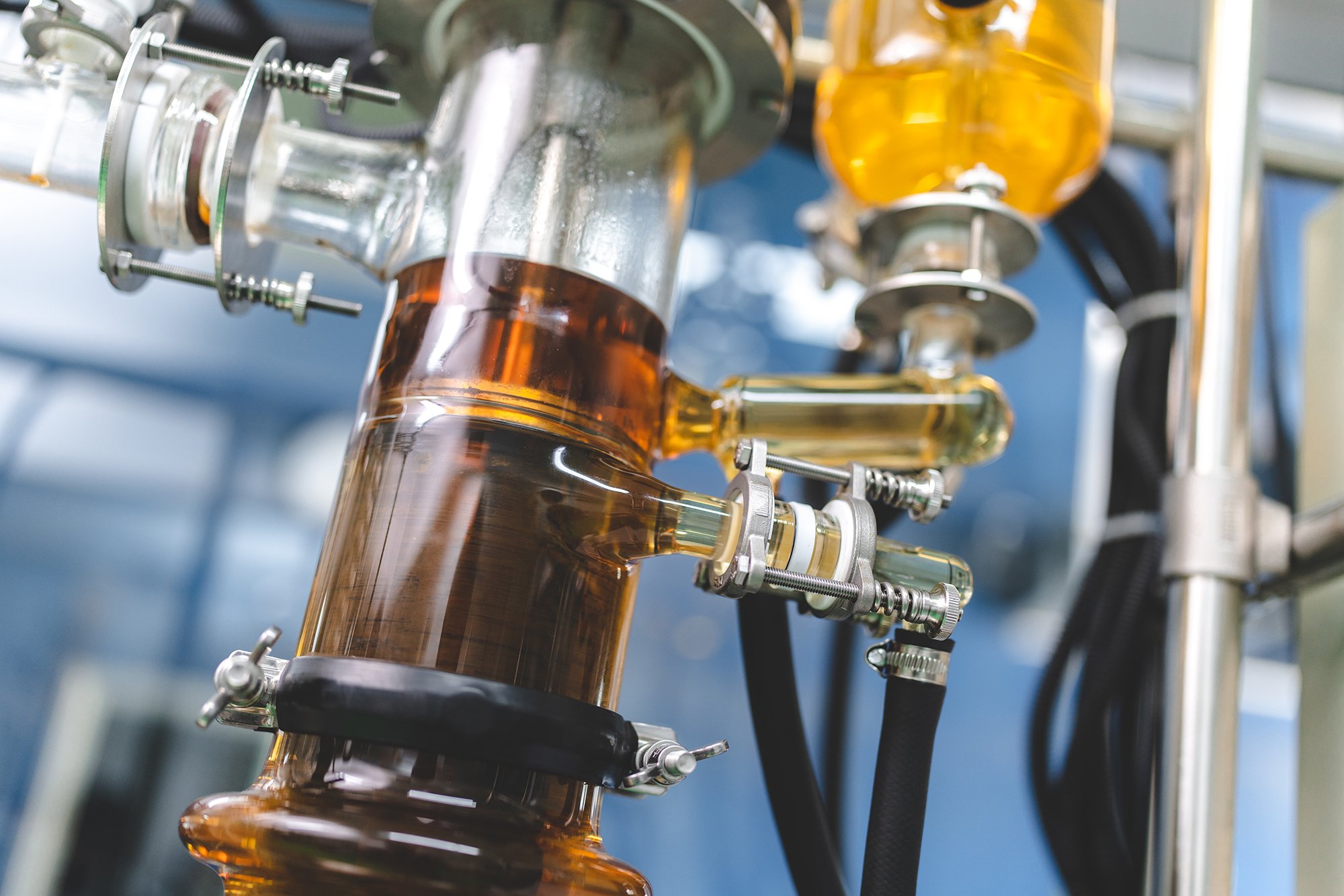Reactor de laboratorio con líquidos de diferentes colores, usado para experimentos químico o procesos de investigación.