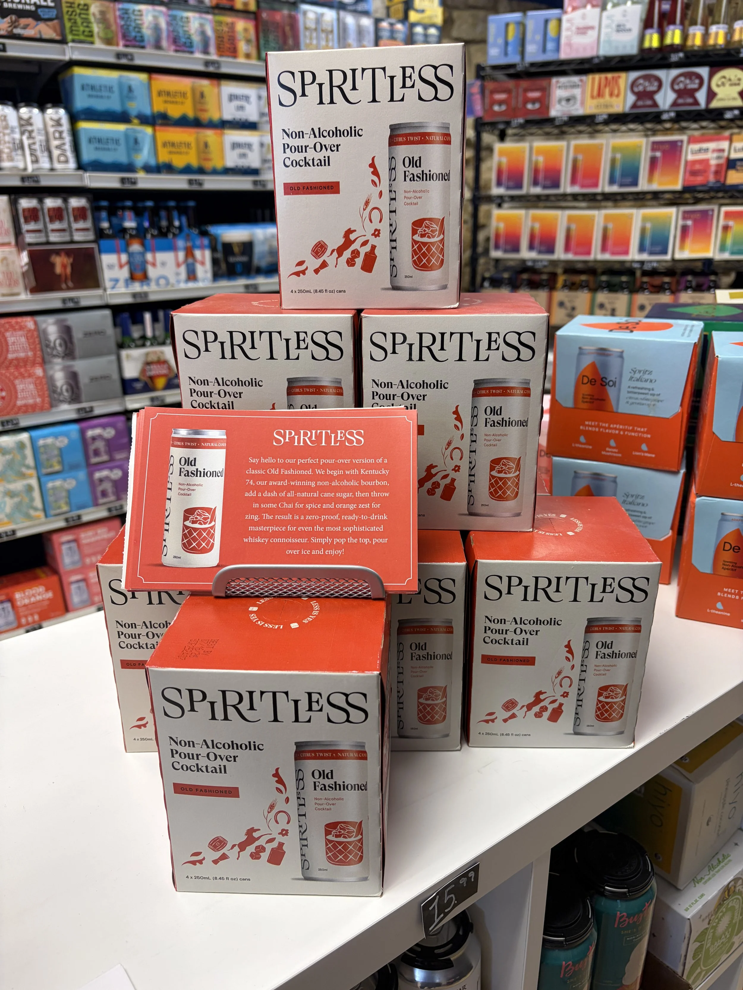 A display of Spiritless non-alcoholic cocktail boxes on a store shelf. The boxes are white with red and black text and graphics, advertising an Old Fashioned non-alcoholic drink at Neer Beer Beverage Company in Wheaton Illinois