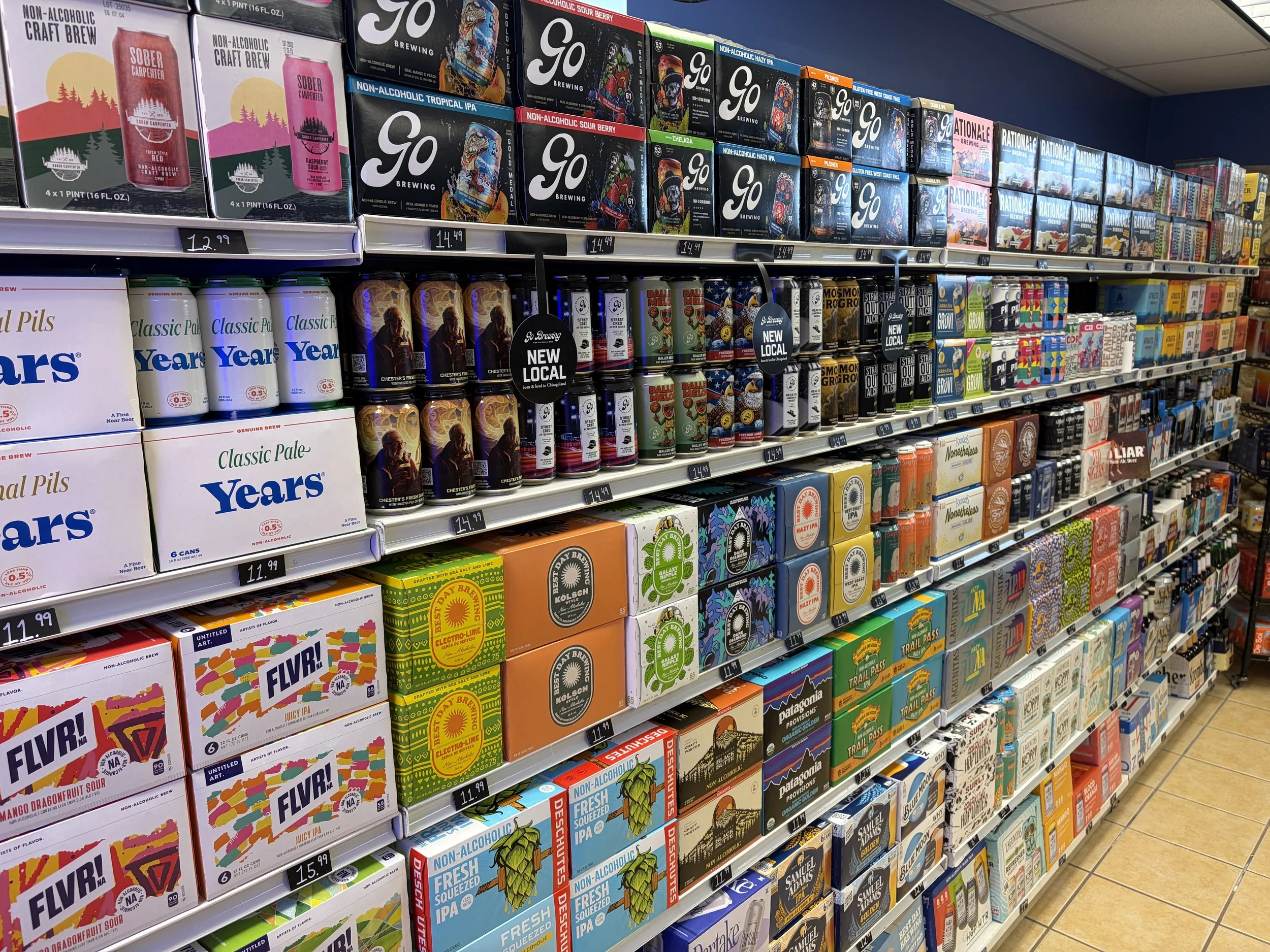 Bottle shop store shelf stocked with various non-alcoholic craft beers and non-alcoholic beverages in a store.