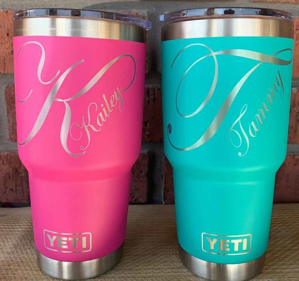 Pink and blue insulated YETI tumblers with personalized gold script labels: one labeled "Kailyn" and the other labeled "Tammy."