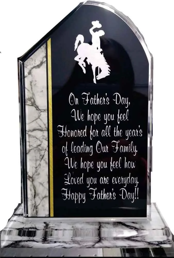 A black and white marble tombstone with a gold stripe on the left and a white horse and rider silhouette at the top. It has a sentimental message for Father's Day engraved on it.