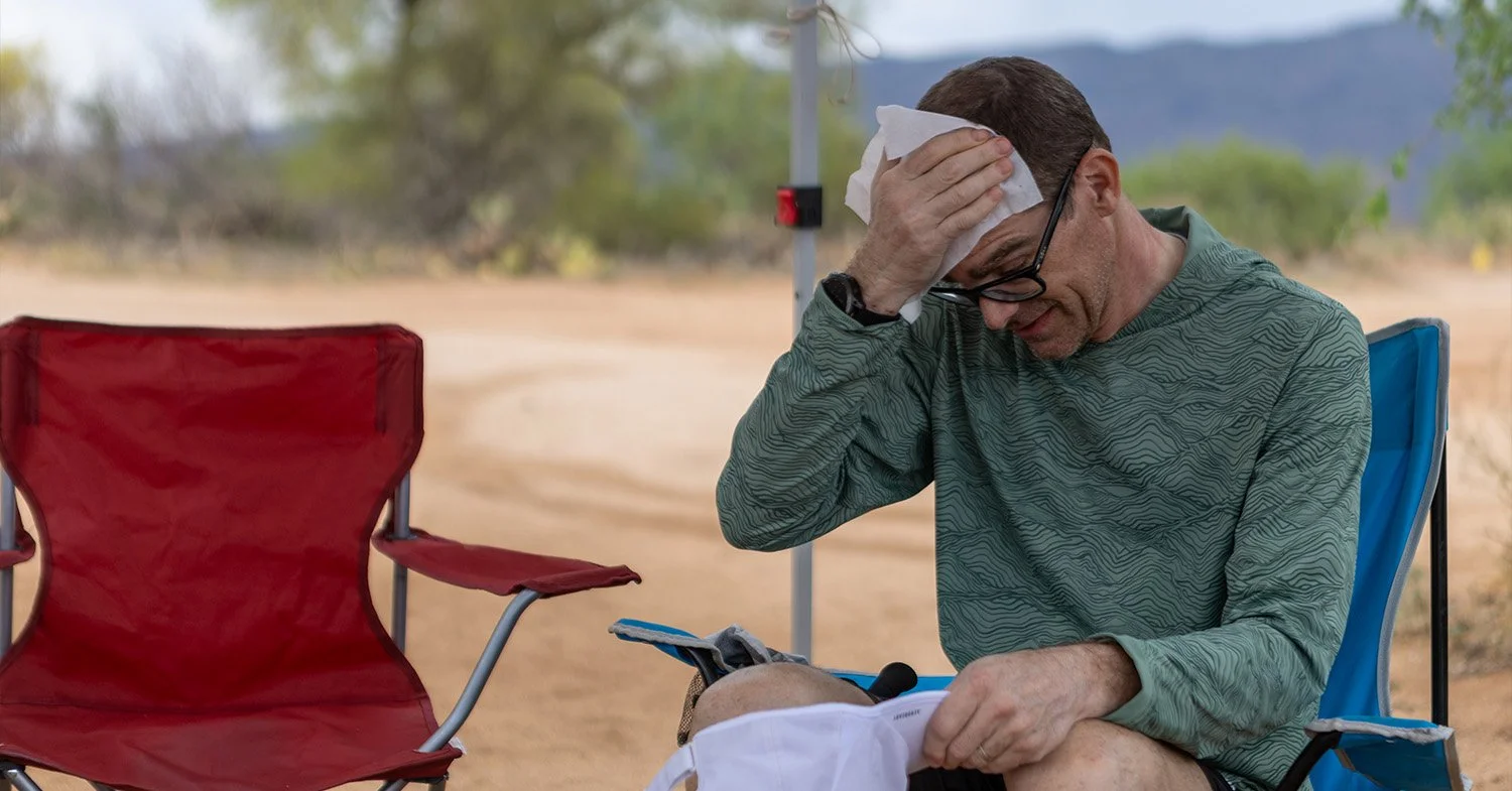 A man rests and whipes his head