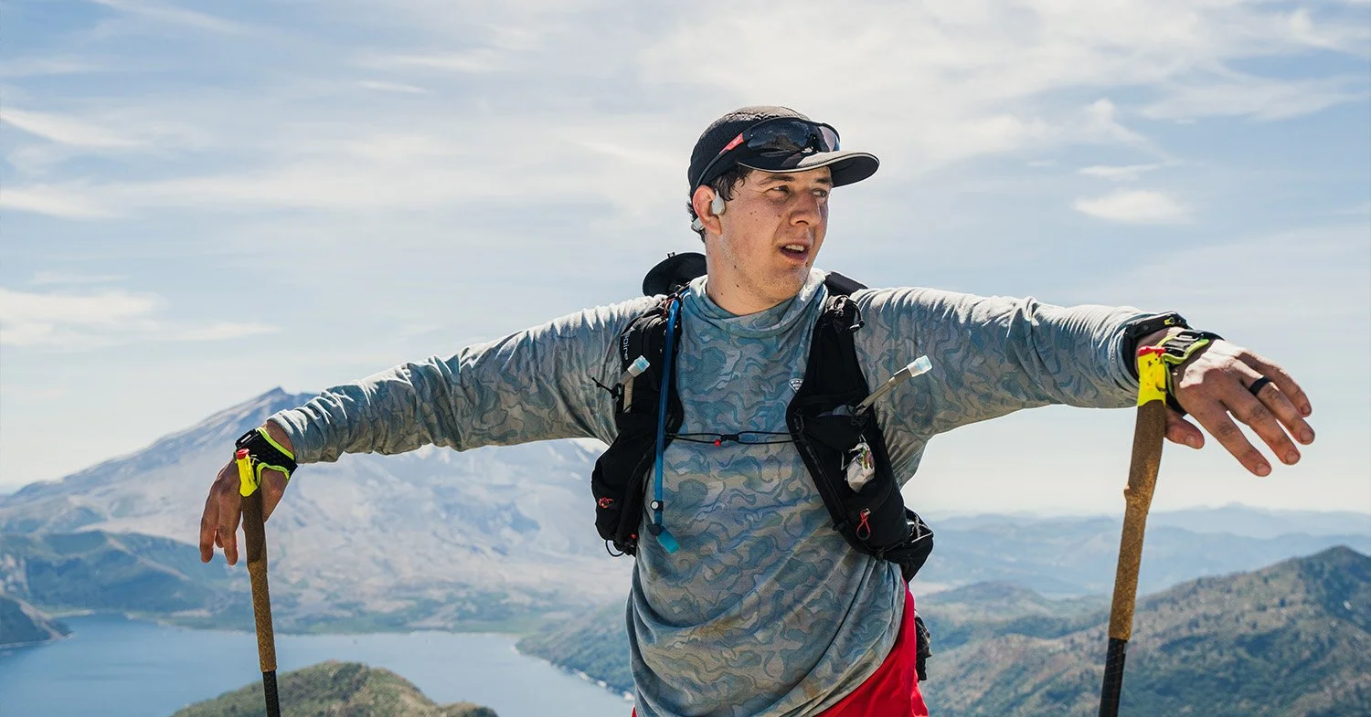 Man rests at a viewpoint with hiking poles in his hands