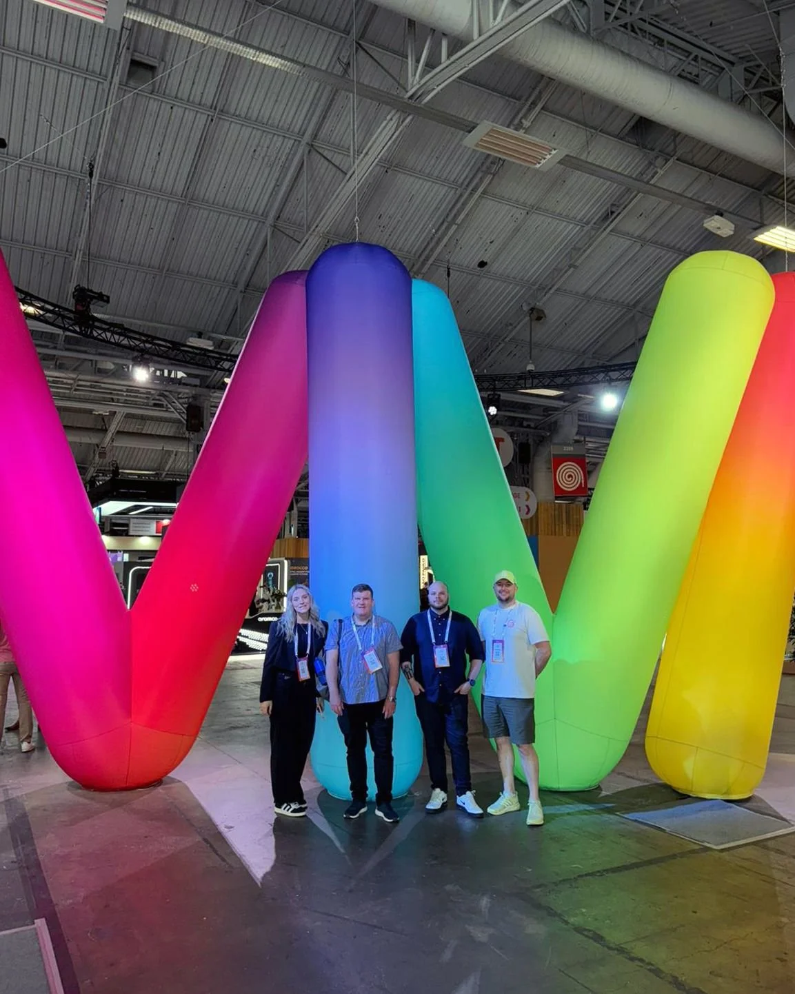 Four coworkers stand in front of giant balloons