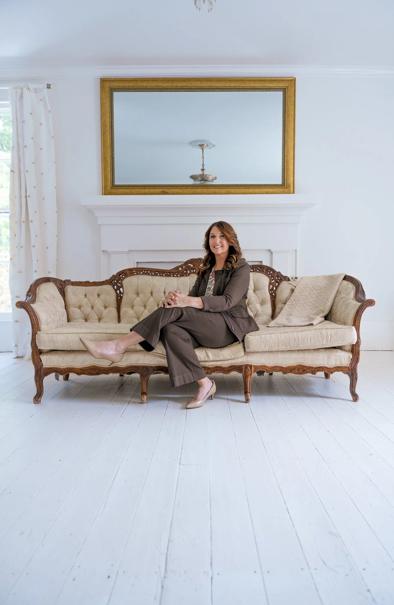 Angela Snider sitting on elegant couch in white room