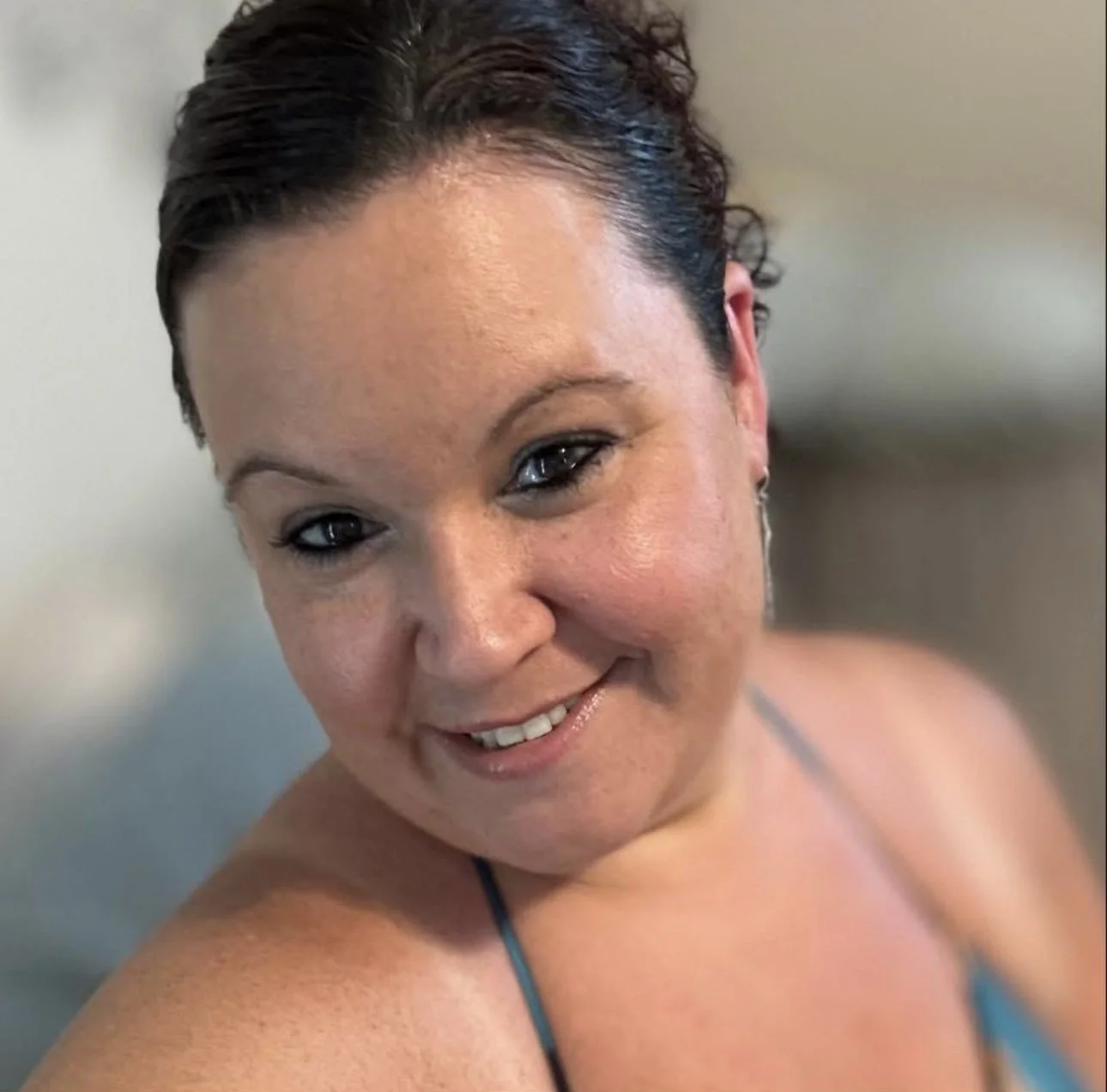A woman with short dark hair smiling at the camera.