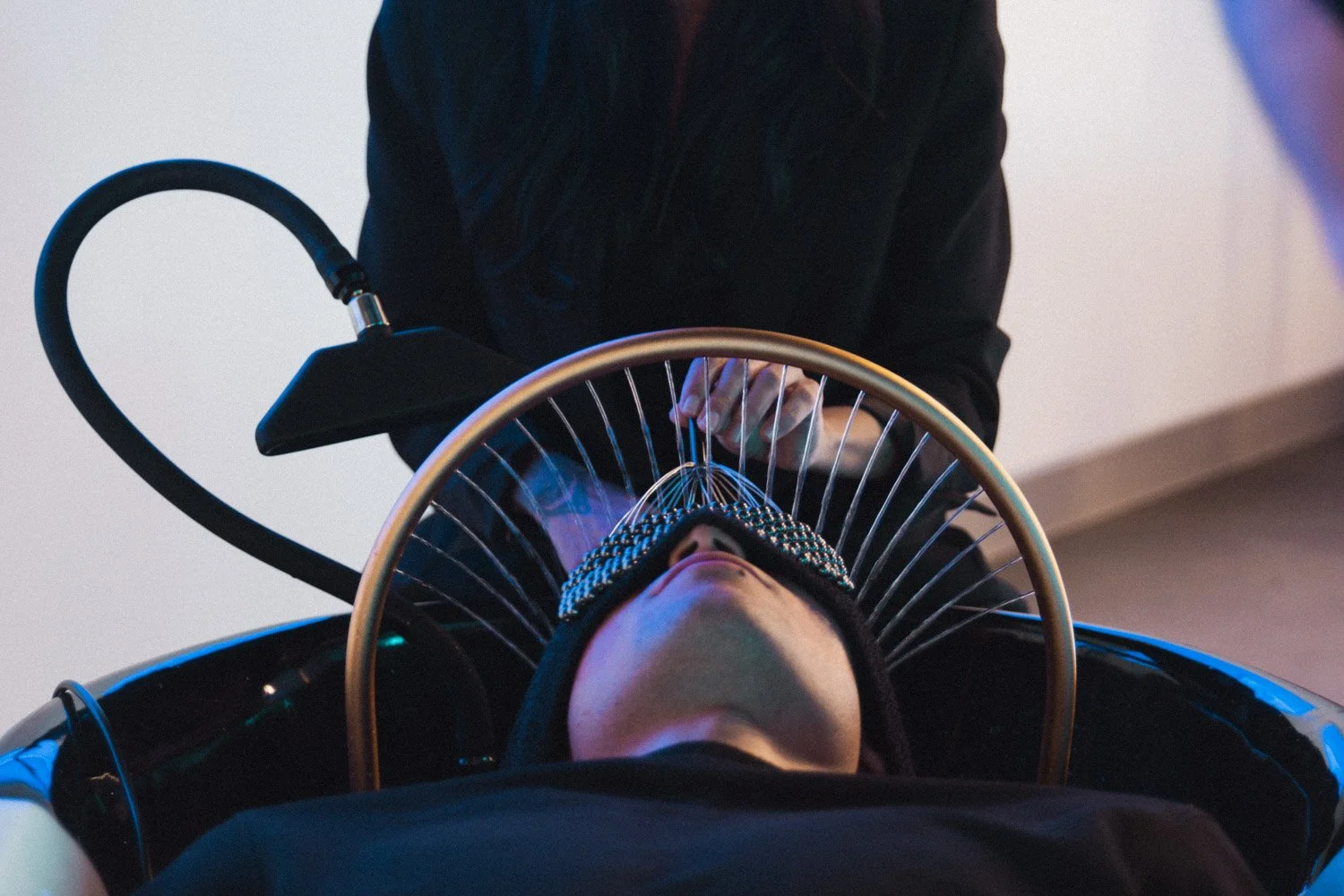 Une personne allongéereçoit un traitement capillaire head spa / spa de tête avec massage crânien.