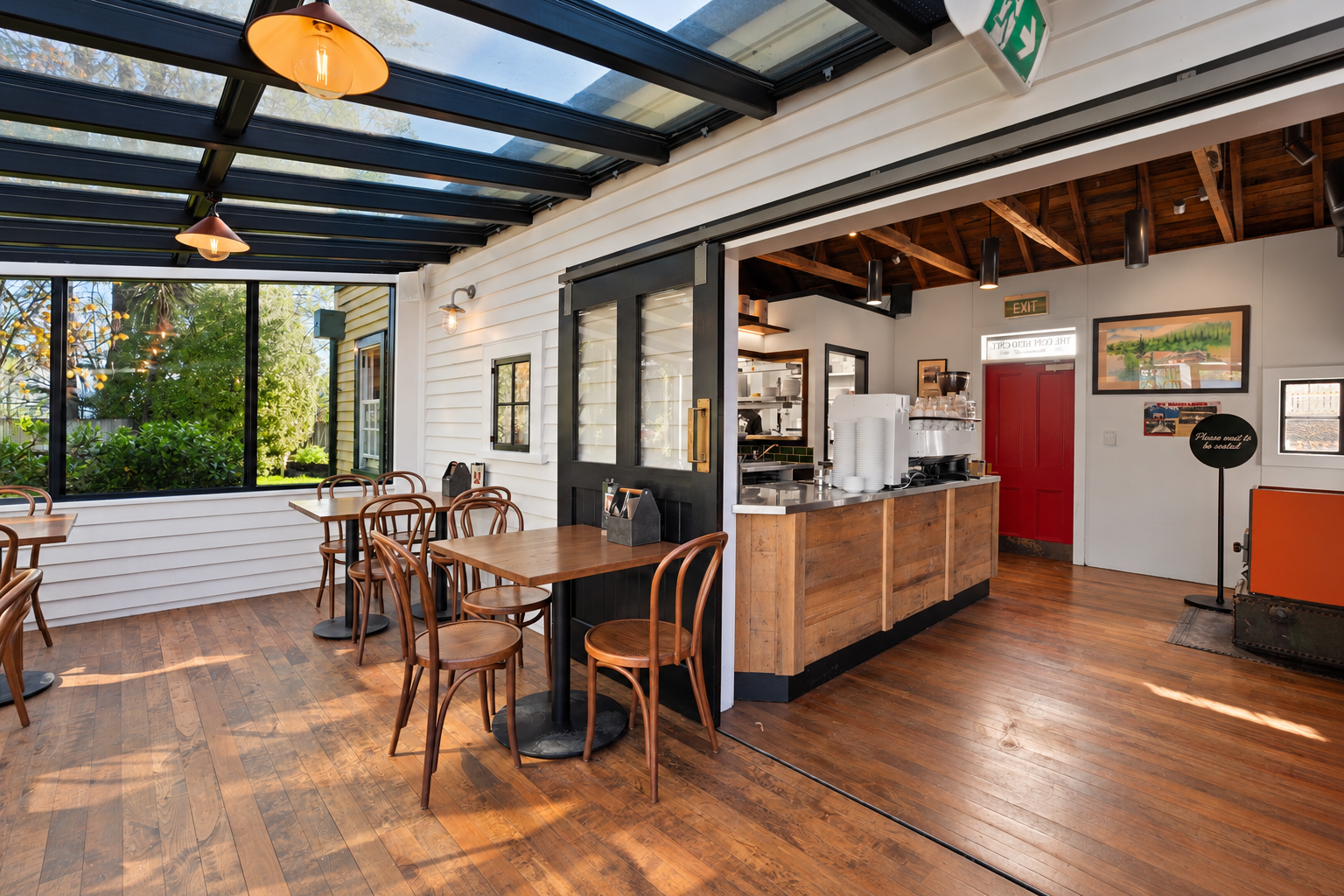Cafe dining area looking towards red door and timber service counter, Frankton Marina