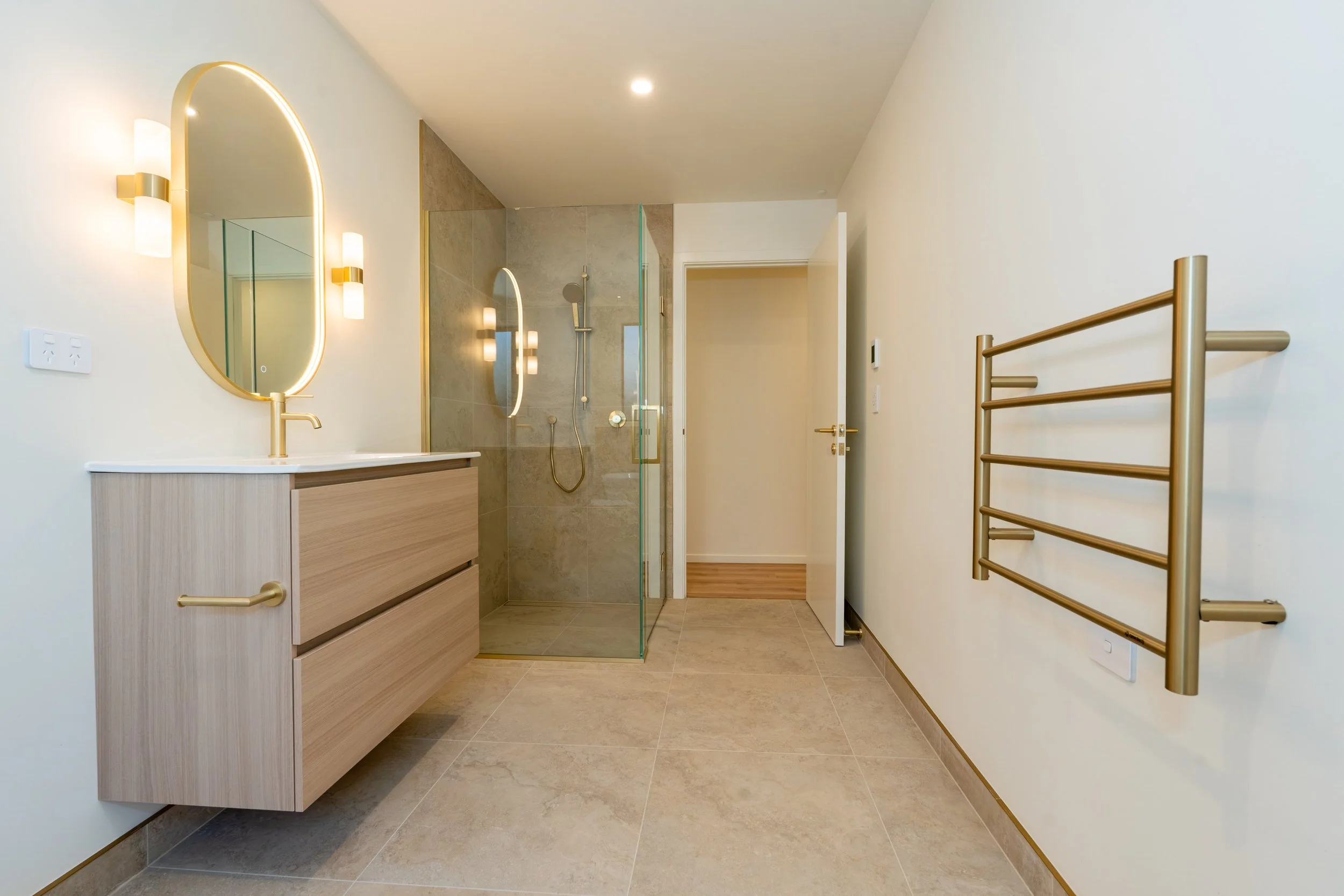Modern family bathroom with a freestanding bath, walk-in tiled shower and custom vanity, showcasing quality craftsmanship and premium finishes by Adept Carpentry.