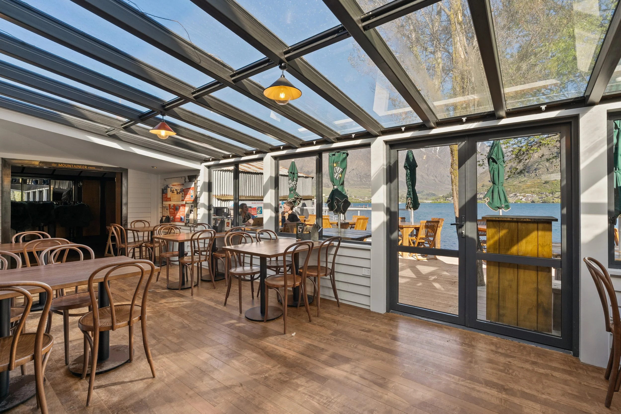 Glasshouse dining area with glass roof and garden doors, Frankton Marina cafe