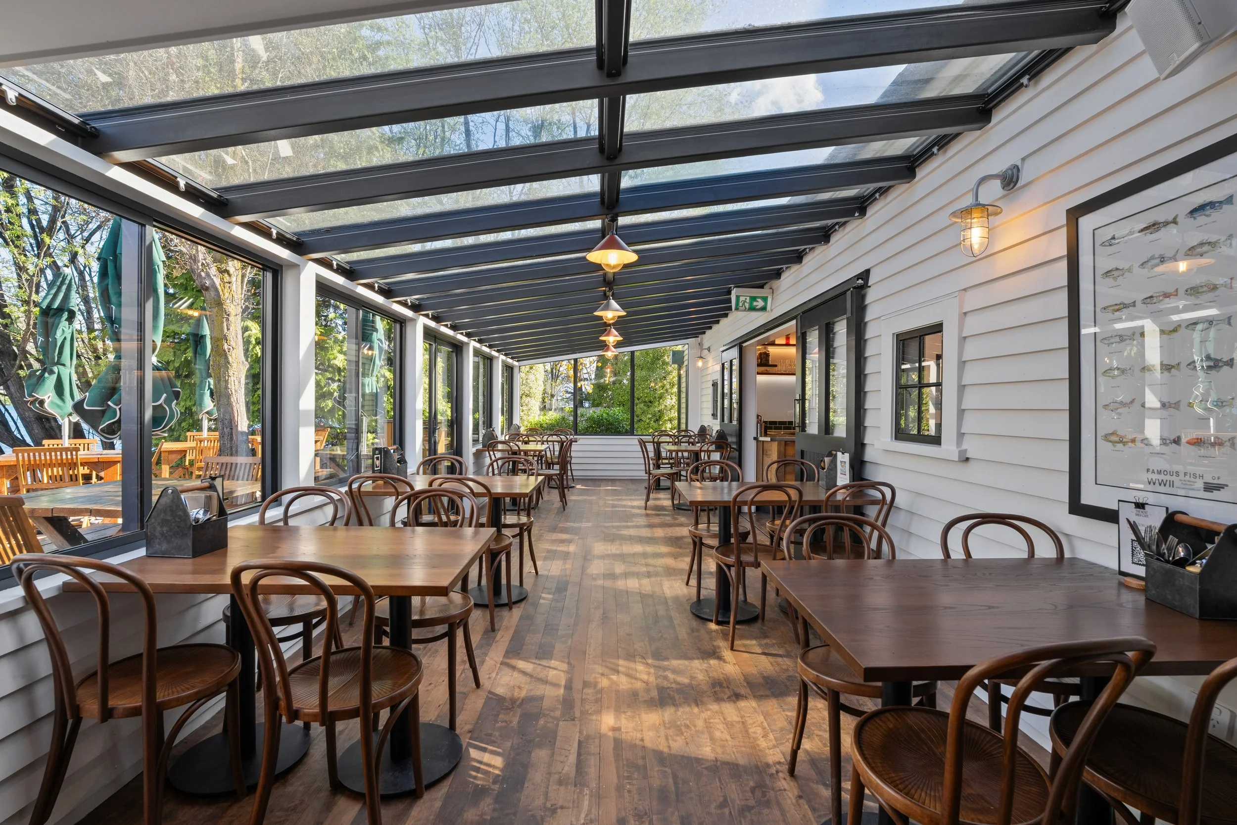 Glass-roofed dining room with timber tables and bentwood chairs, Boat Shed Cafe Queenstown