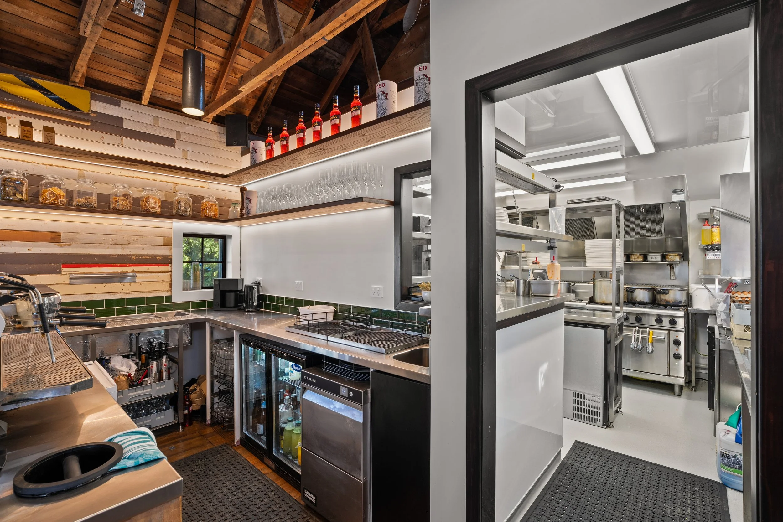 Kitchen and bar area with under-bench fridges, viewed through doorway, Boat Shed Cafe
