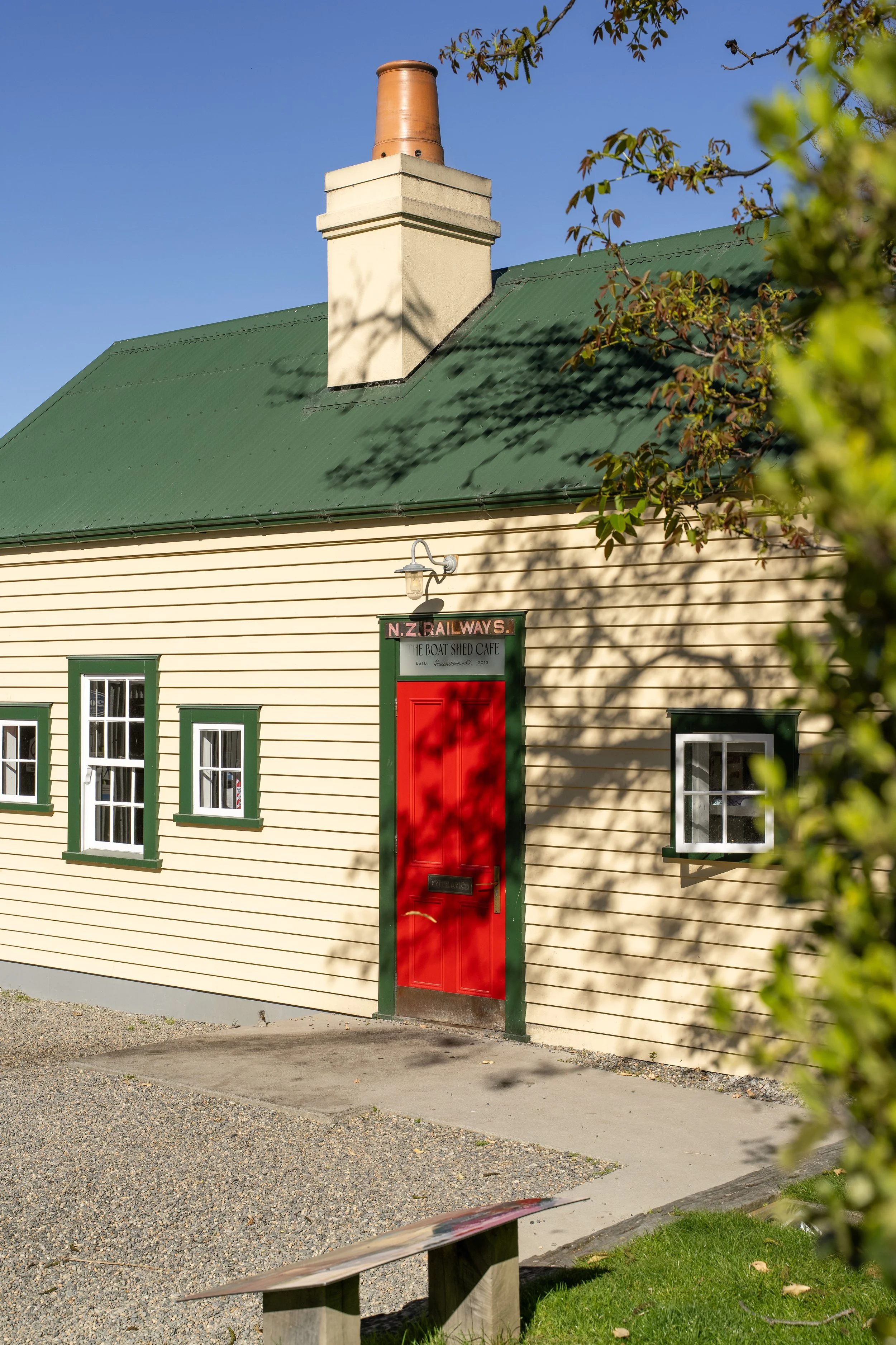 Heritage Boat Shed Cafe exterior with red door and green roof, Frankton Marina, Queenstown