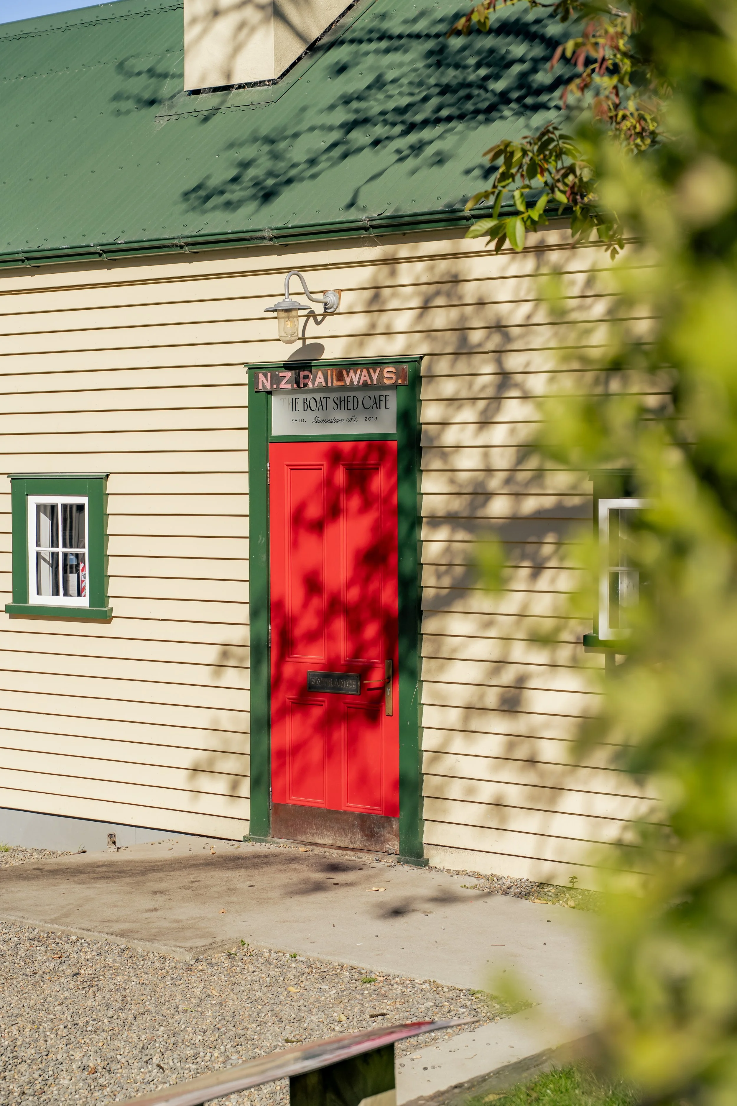 Close-up of heritage cafe entrance with red door and green trim, Frankton Marina