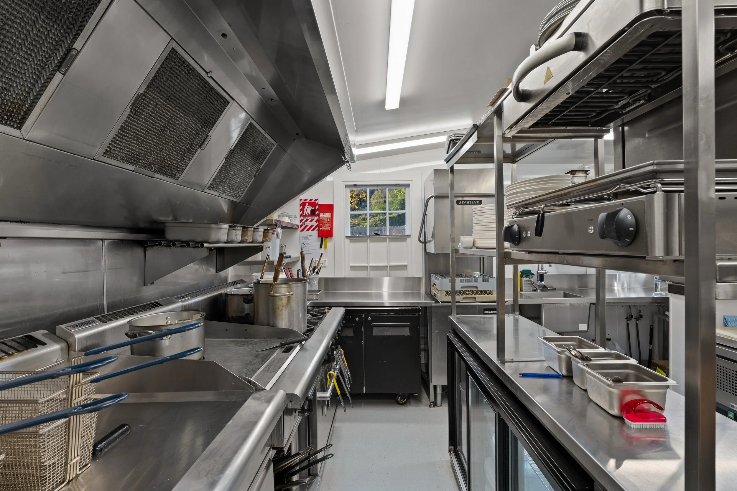 Stainless steel kitchen with extraction hood and cooking line, hospitality fit-out Queenstown