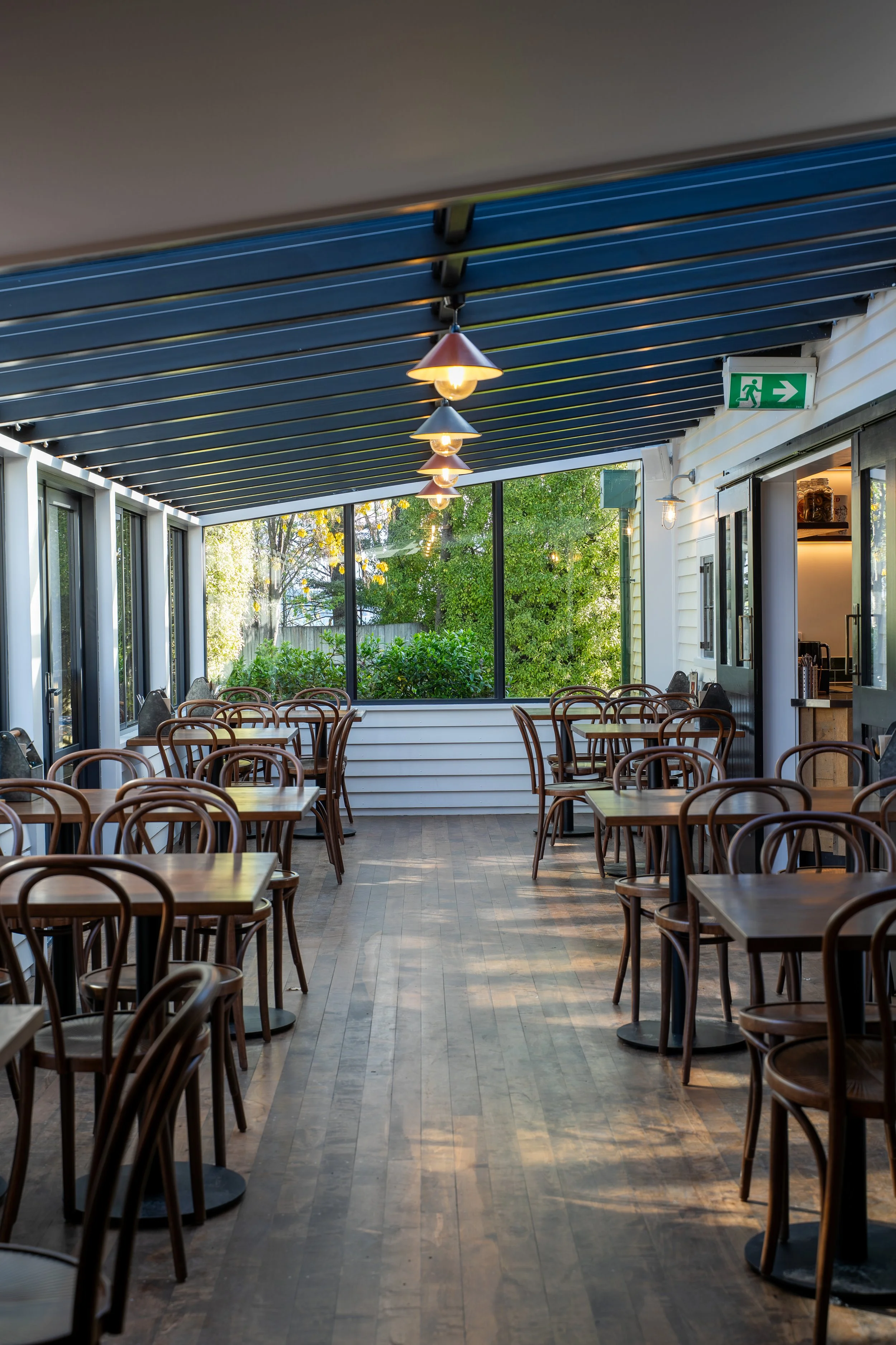 Covered dining area with pendant lights and garden views, Boat Shed Cafe Queenstown