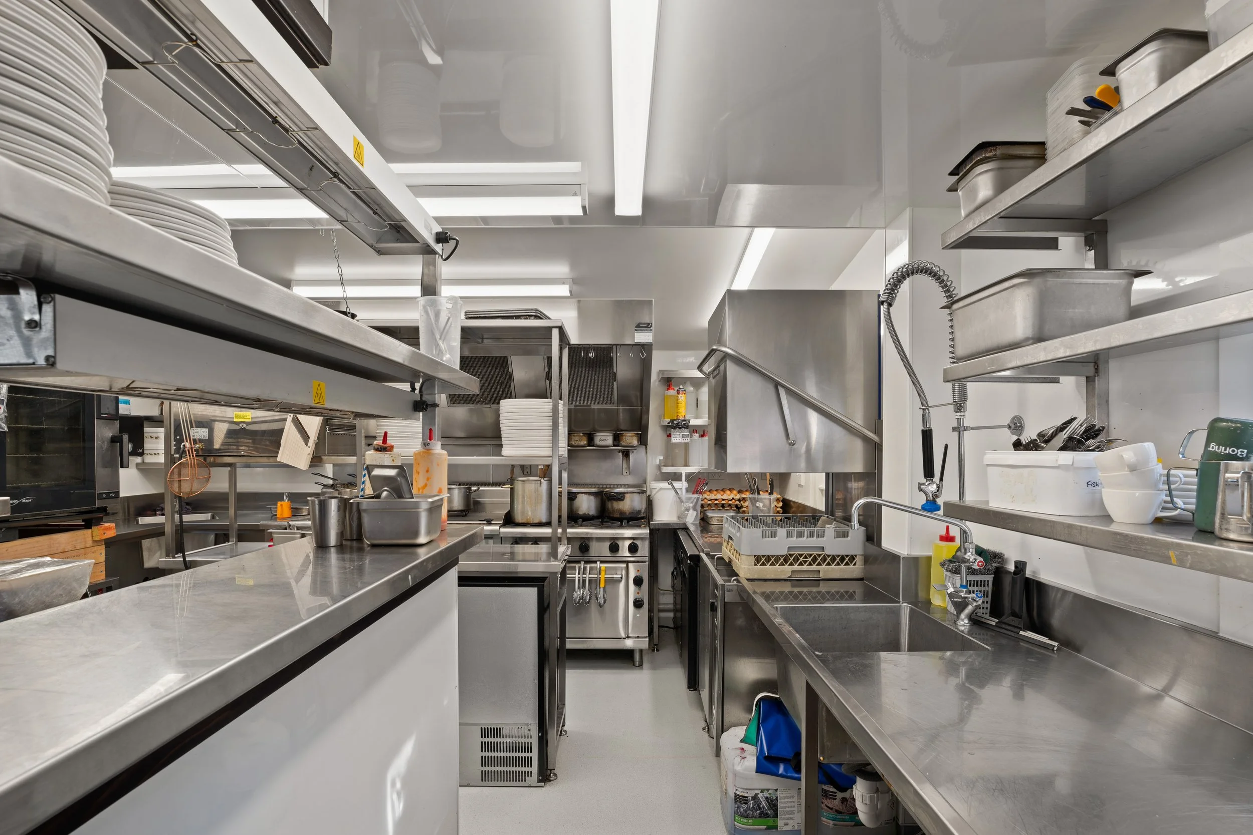 Commercial kitchen with stainless steel benches and sink, Boat Shed Cafe renovation