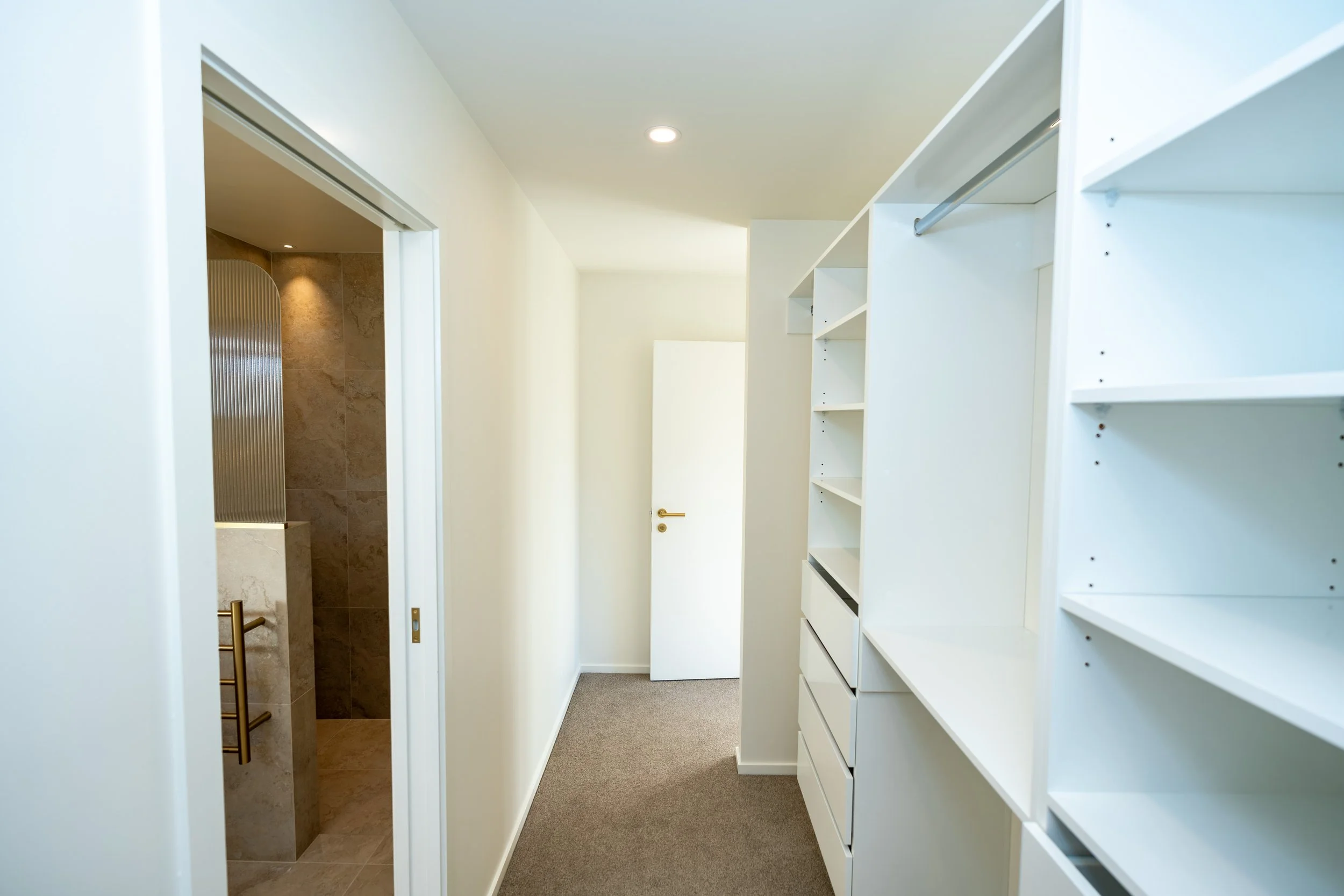 Custom walk-in wardrobe featuring bespoke oak cabinetry, generous storage solutions and contemporary joinery in a modern Queenstown home by Adept Carpentry.