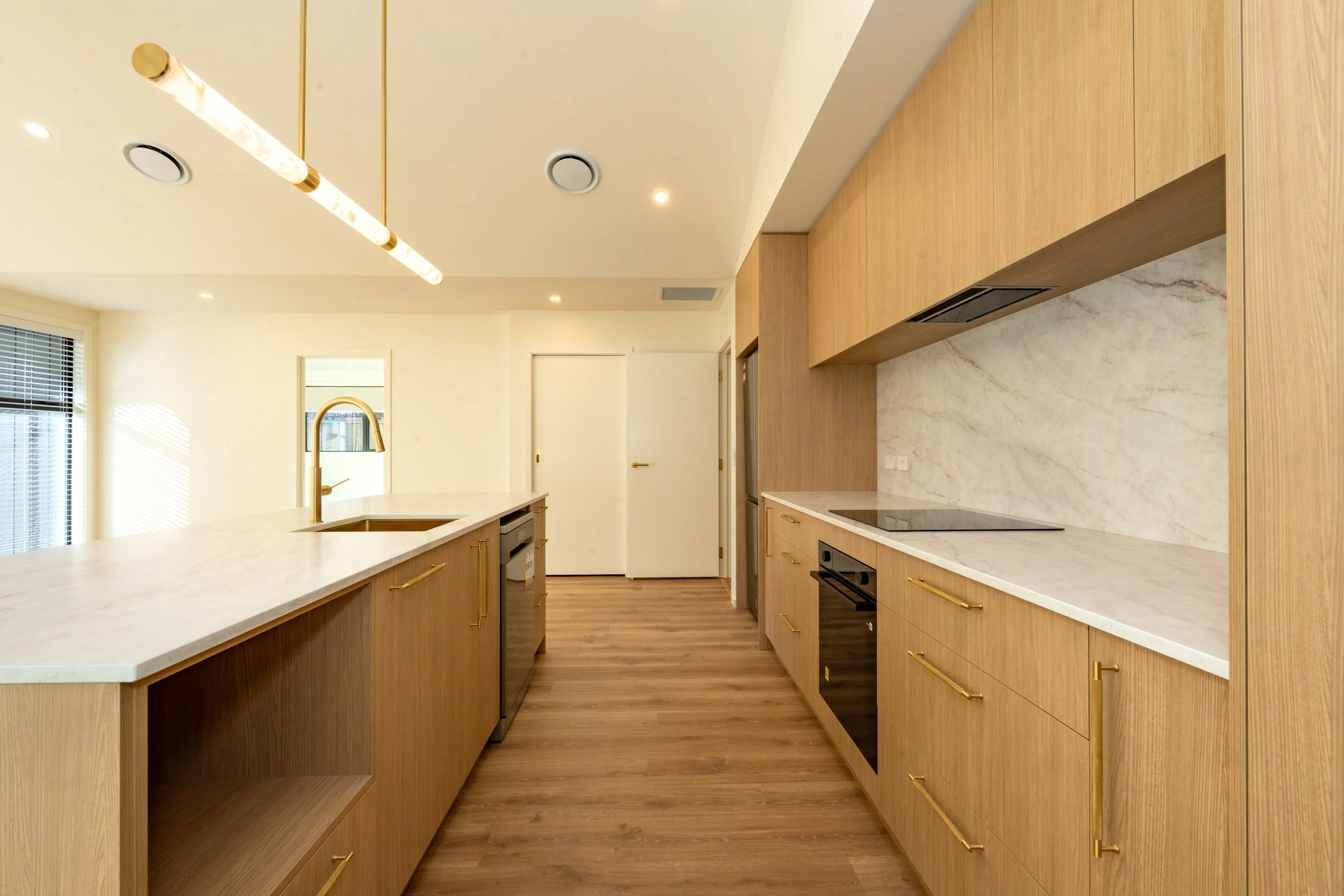 Bright open-plan living and kitchen featuring Scandinavian-inspired styling, custom cabinetry, premium finishes and contemporary residential construction in Queenstown.