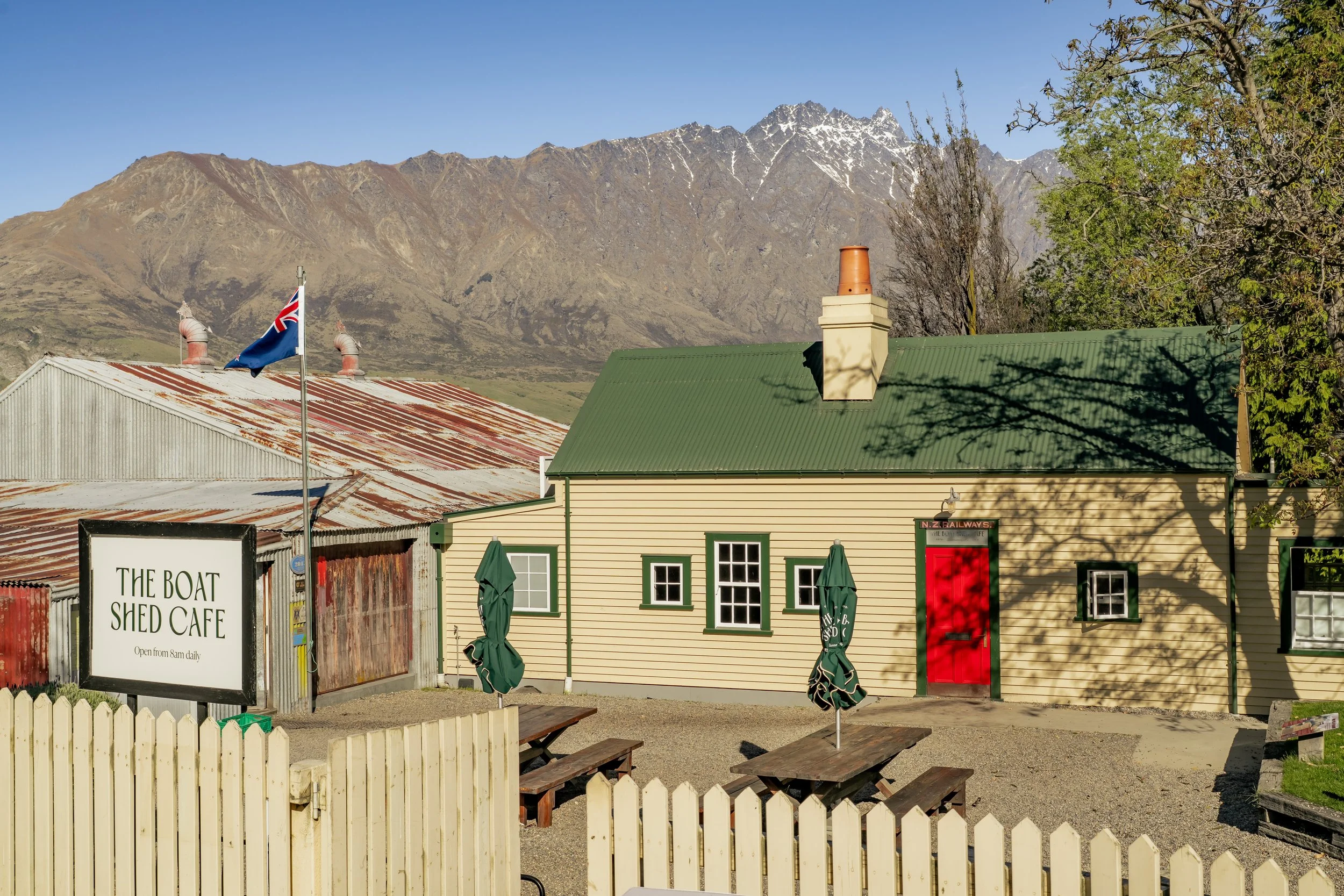 Boat Shed Cafe exterior with picket fence and Remarkables mountain view, Queenstown