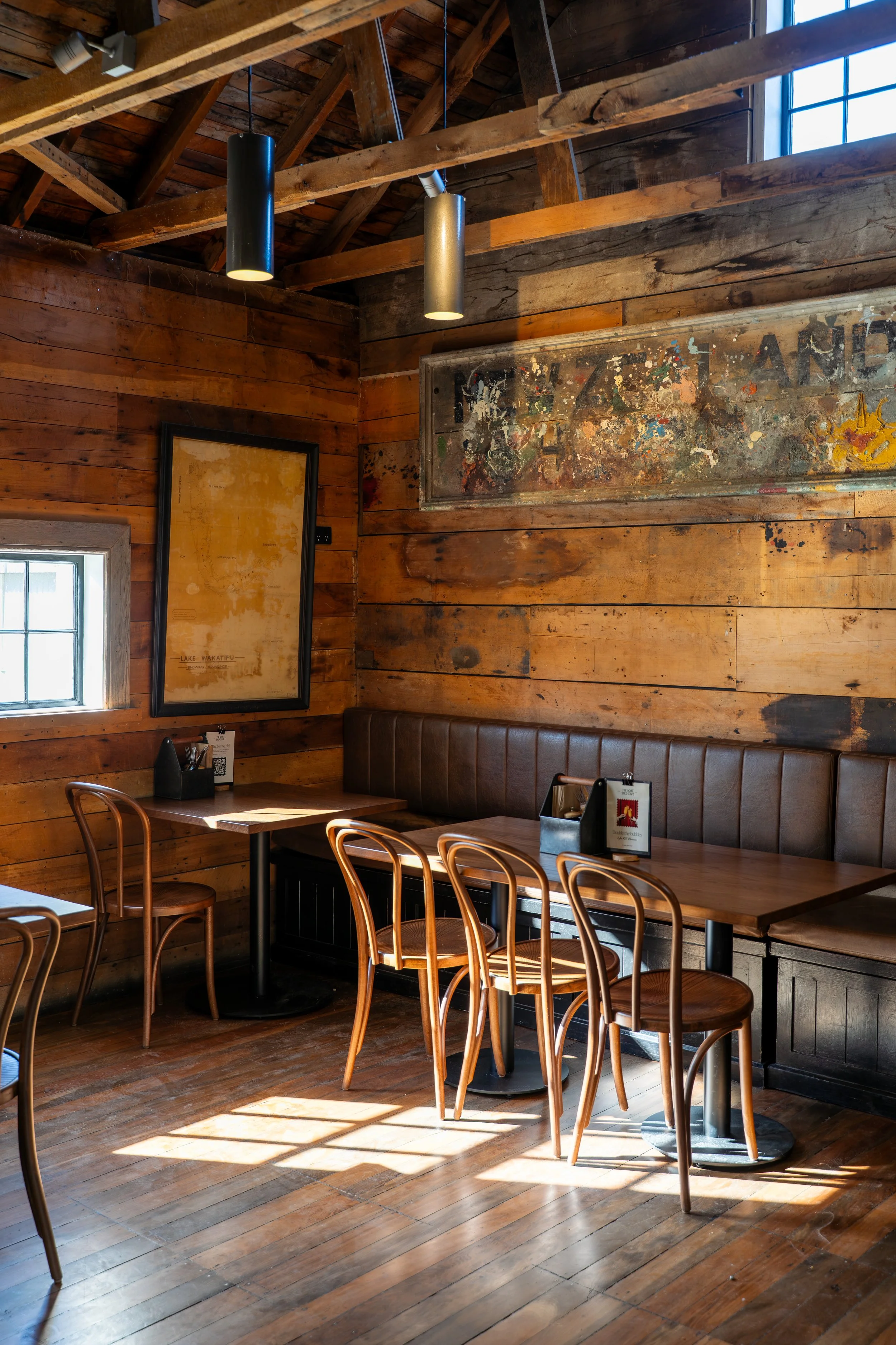 Booth seating with leather banquette and reclaimed timber walls, heritage cafe fit-out