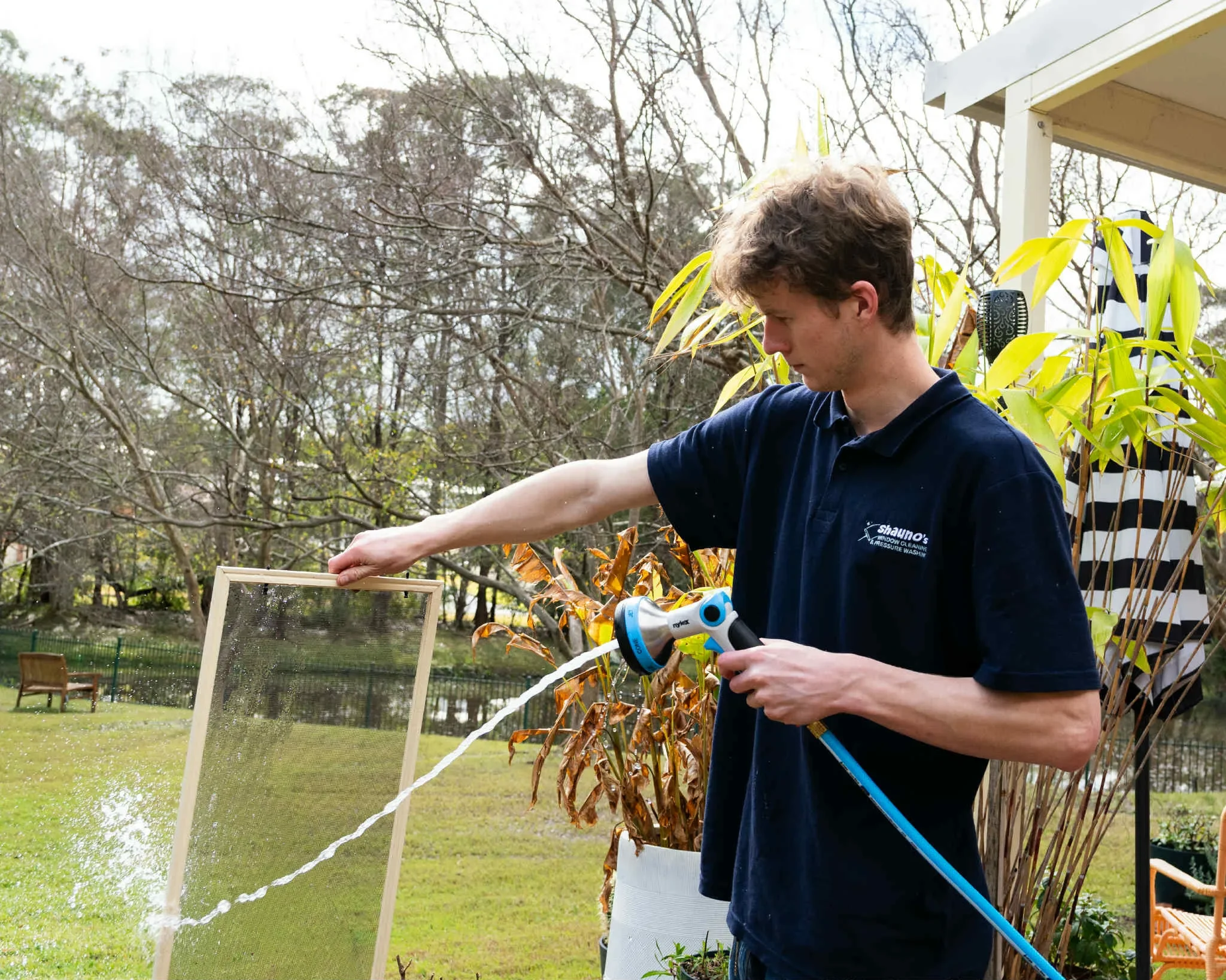 Hard working Shaunos employee cleaning window screens on Central Coast