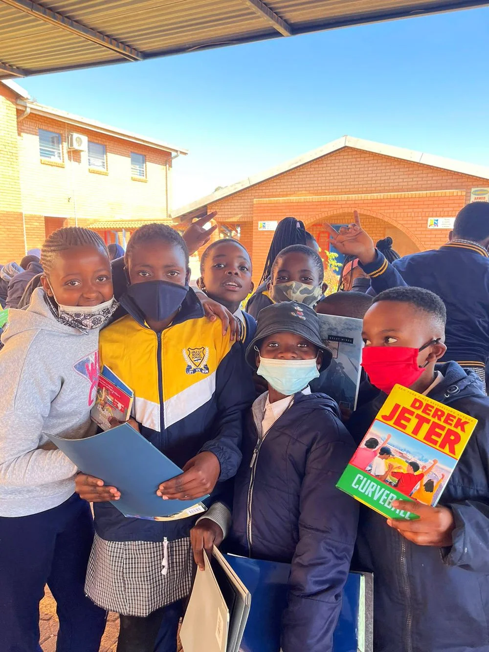 Students holding up books from a COSAS shipment at Lenasia Model Primary School in Johannesburg, South Africa.