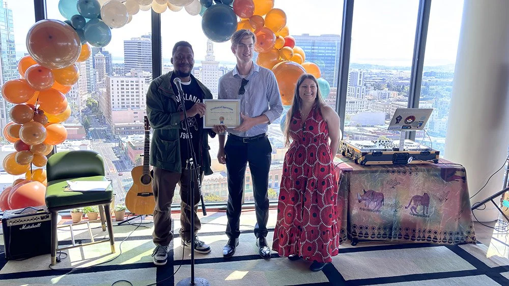 Golden Hour Books founder Nate Poremba (center) received a certificate of appreciation from COSAS Operations Manager Nicole Richards (right) and COSAS Board of Directors member Chiedu Ufoegbune (right).