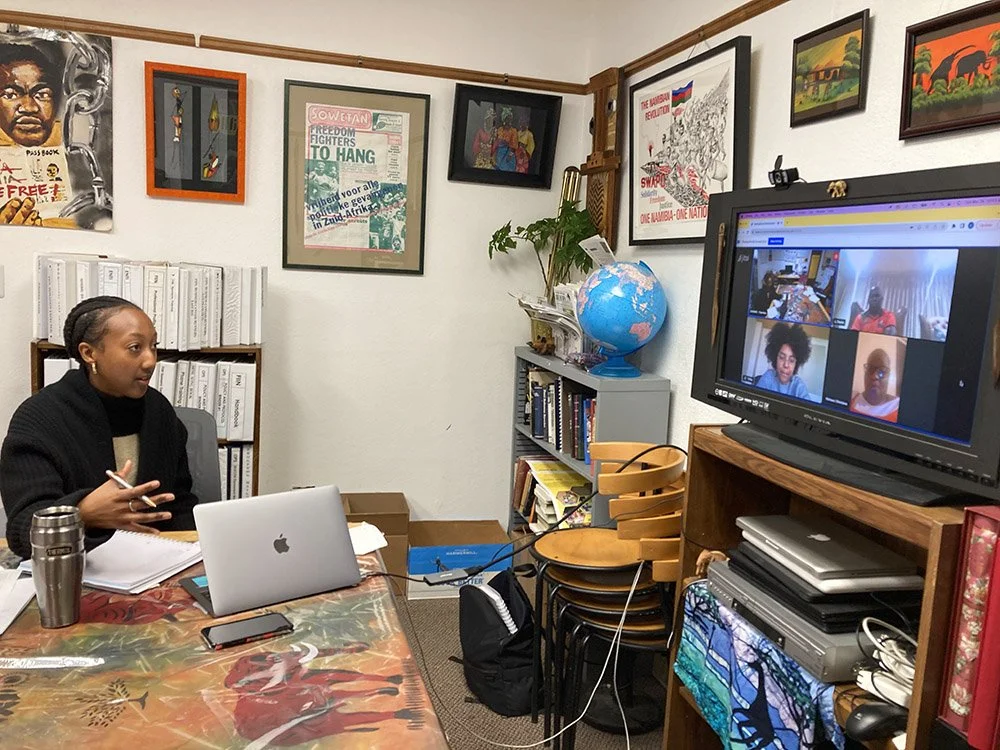 COSAS organizers speaking to someone virtually. The organizer is speaking into a screen that shows multiple people present.