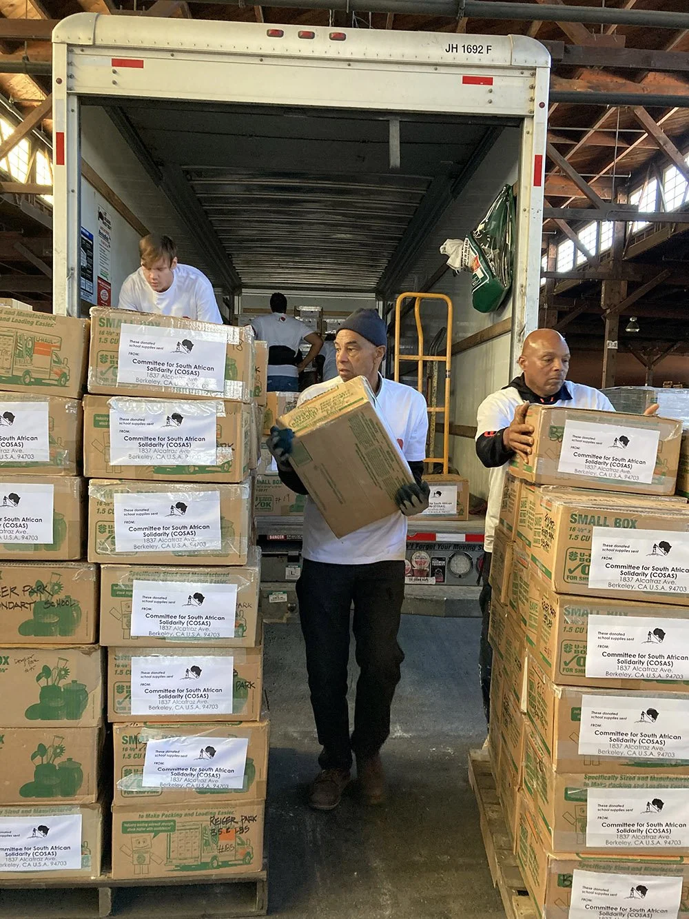 Four COSAS volunteers loading packed boxes on pallets