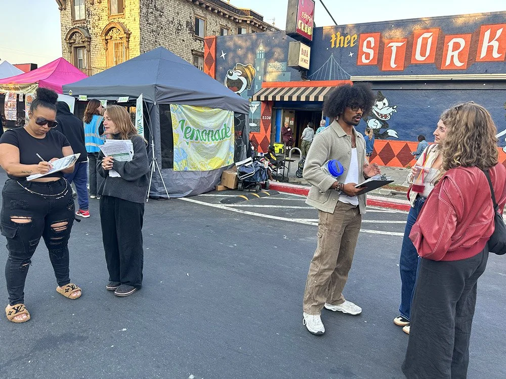 COSAS volunters at an outdoor event, signing up event attendees
