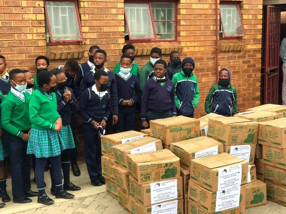 Mthimkhulu Primary School in Vosloorus, South Africa students unloading a truck load of donated school supplies and books from a COSAS shipment.