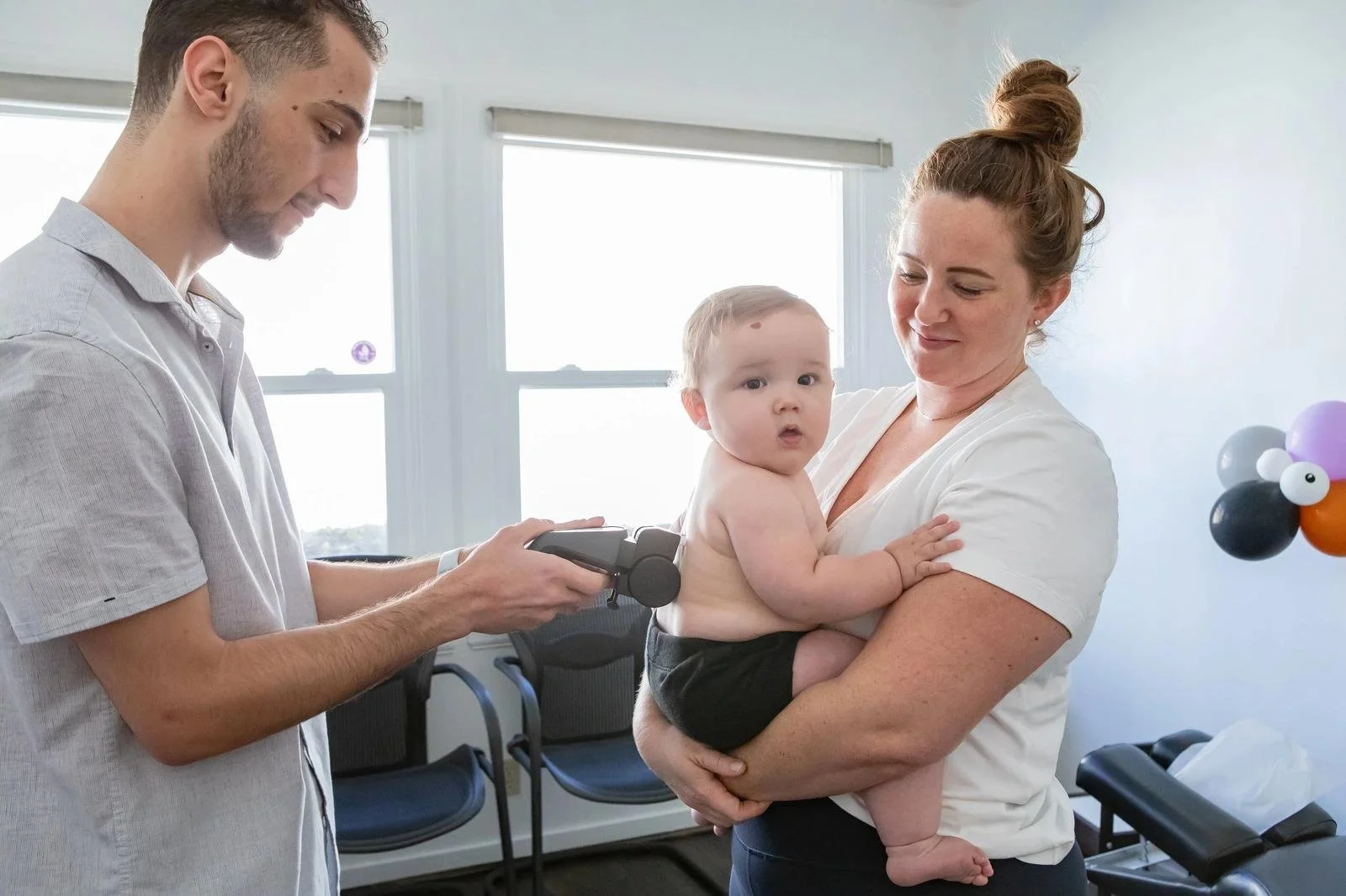 Infant chiropractic assessment at Innate Family Chiropractic Pasadena CA — chiropractor evaluating baby held by mother.