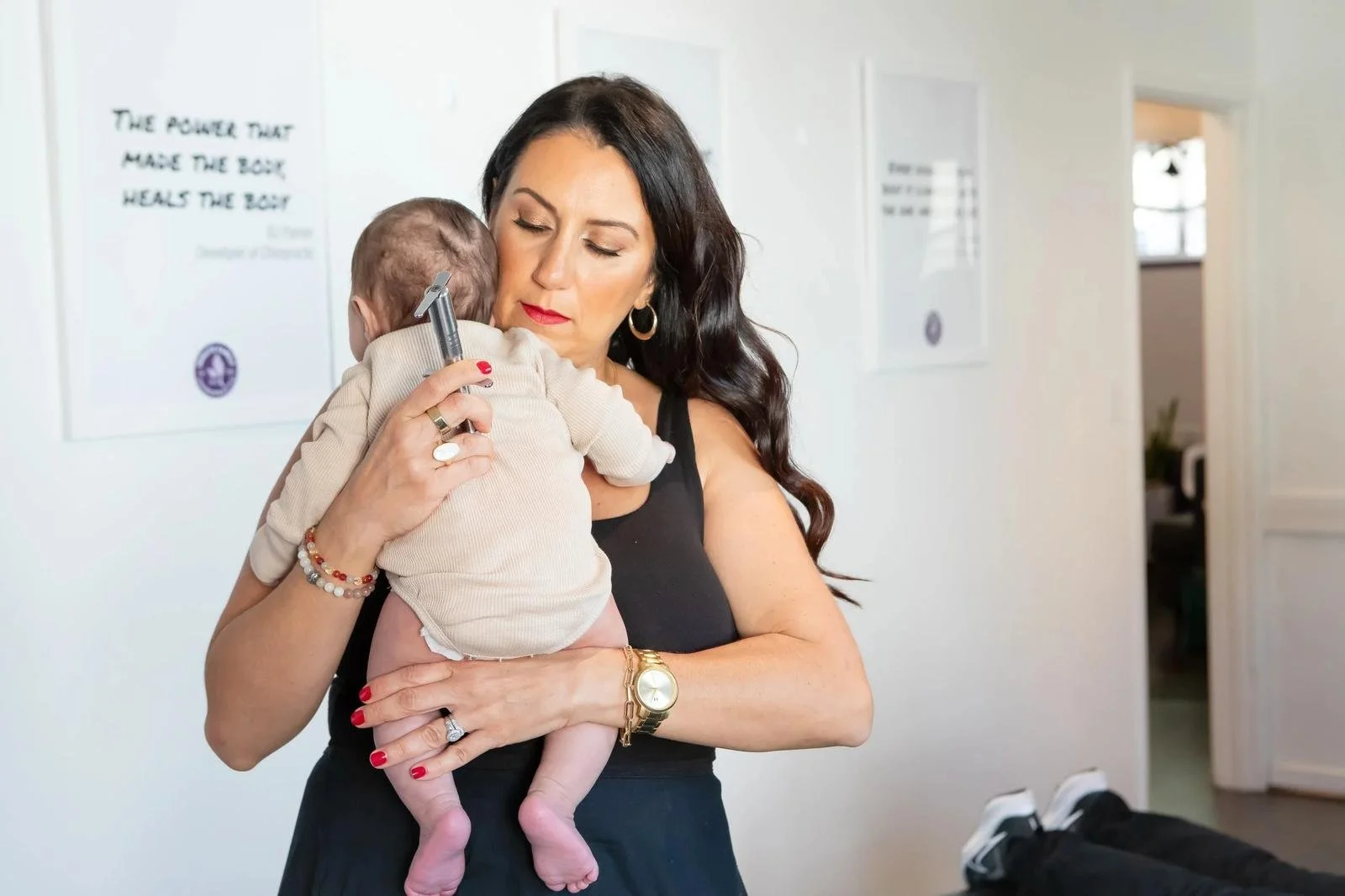 Dr. Adana Vargas of Innate Family Chiropractic Pasadena CA tending to a newborn held by mother.