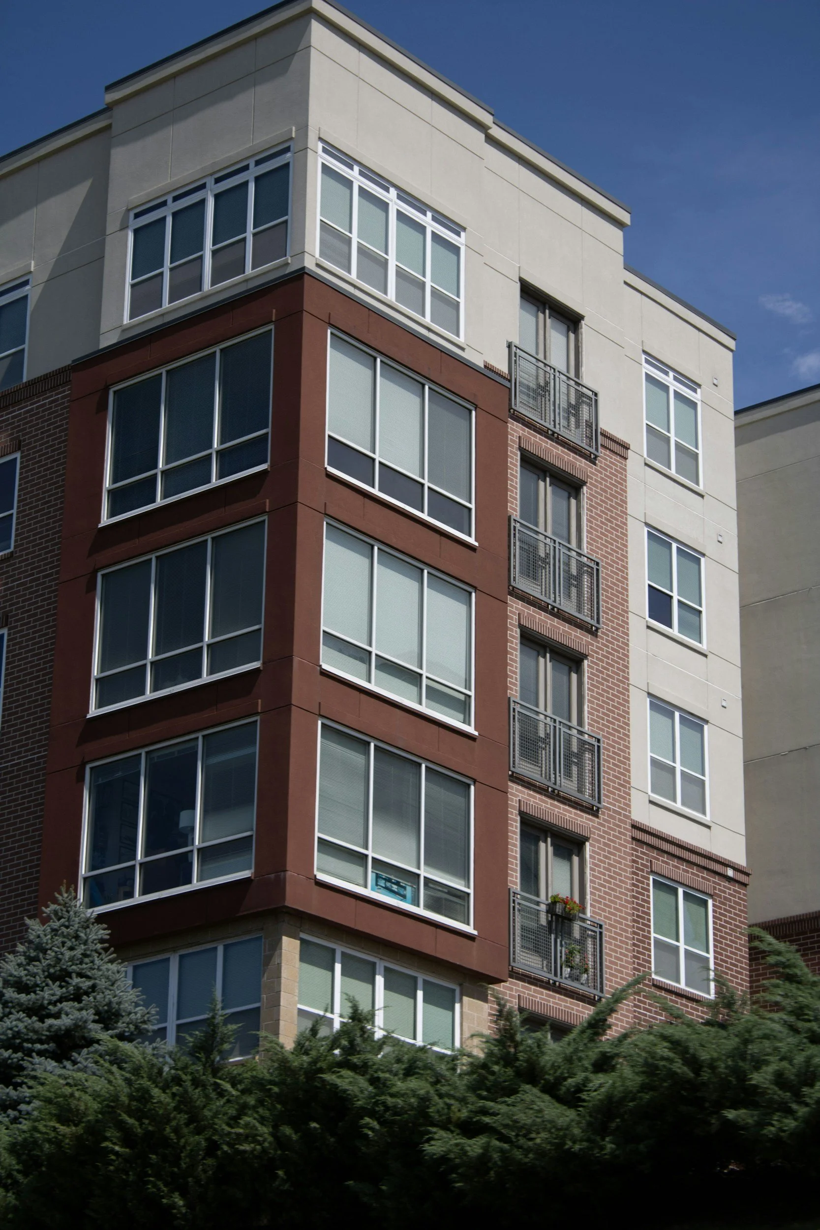 "Modern multi-story residential apartment building with brick and stucco siding, a property development example by DillCo Development Group."