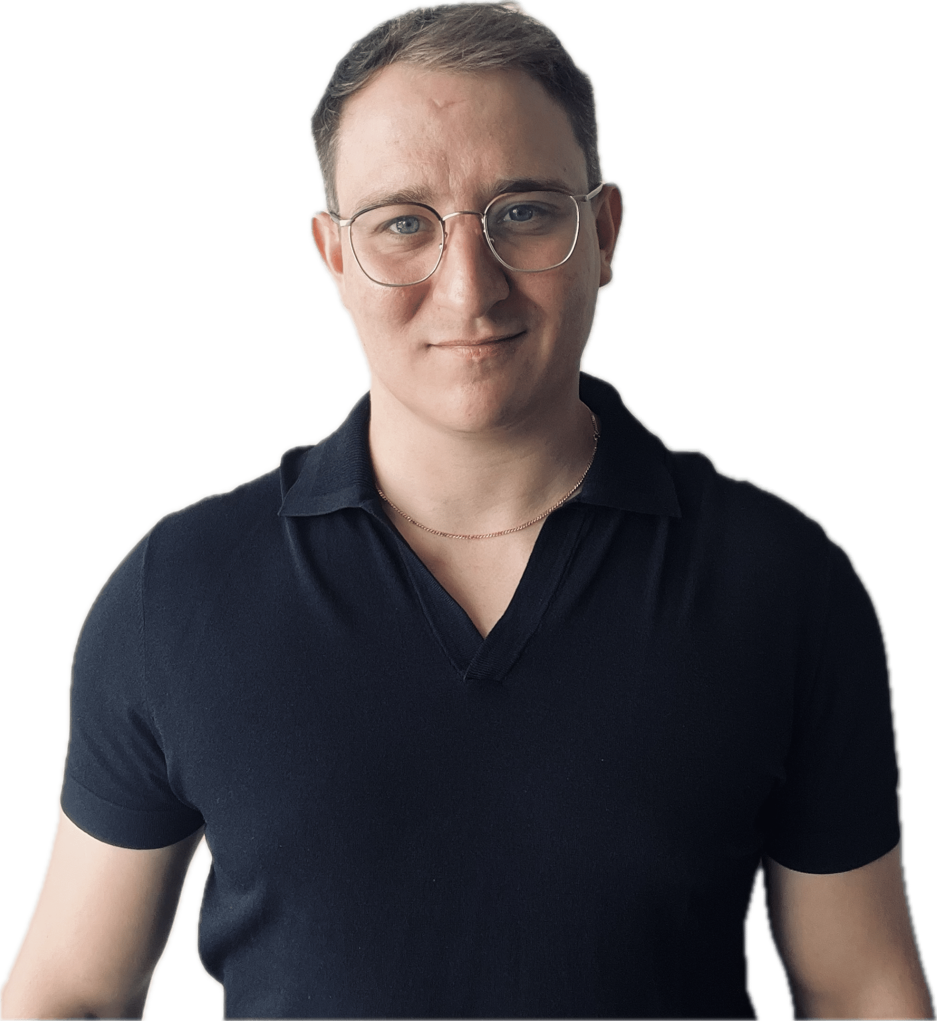 A young man with short brown hair, wearing glasses, a navy blue polo shirt, and a thin gold chain, smiling at the camera.